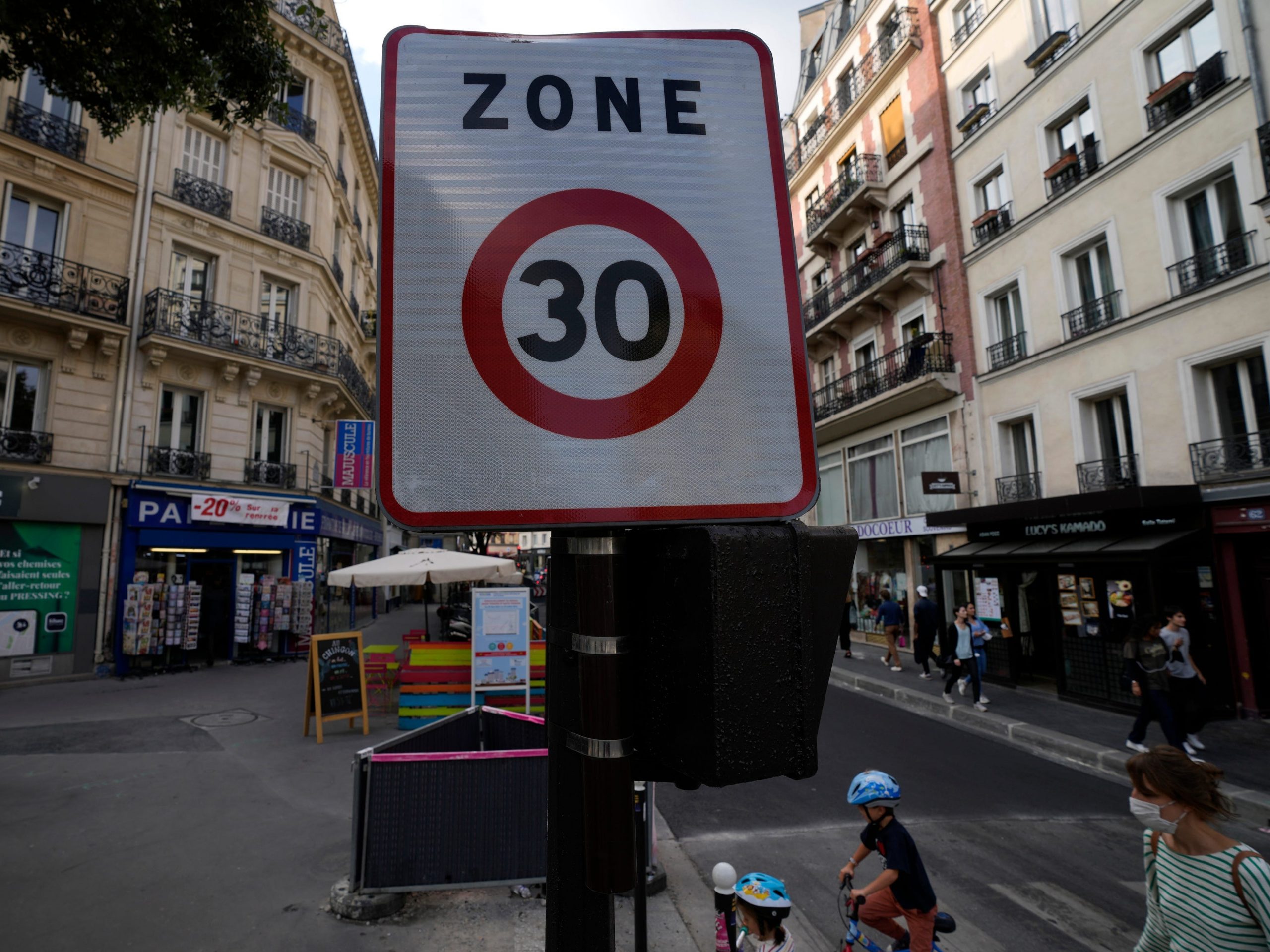 A speed limit road sign is pictured in a street, Monday, Aug. 30, 2021 in Paris as the speed limit on nearly all streets of the French capital is just 30 kph (less than 19 mph). It's the latest initiative by a city trying to burnish its climate credentials and transform people's relationship to their vehicles. City officials say it's also aimed at reducing accidents and making Paris more pedestrian-friendly.