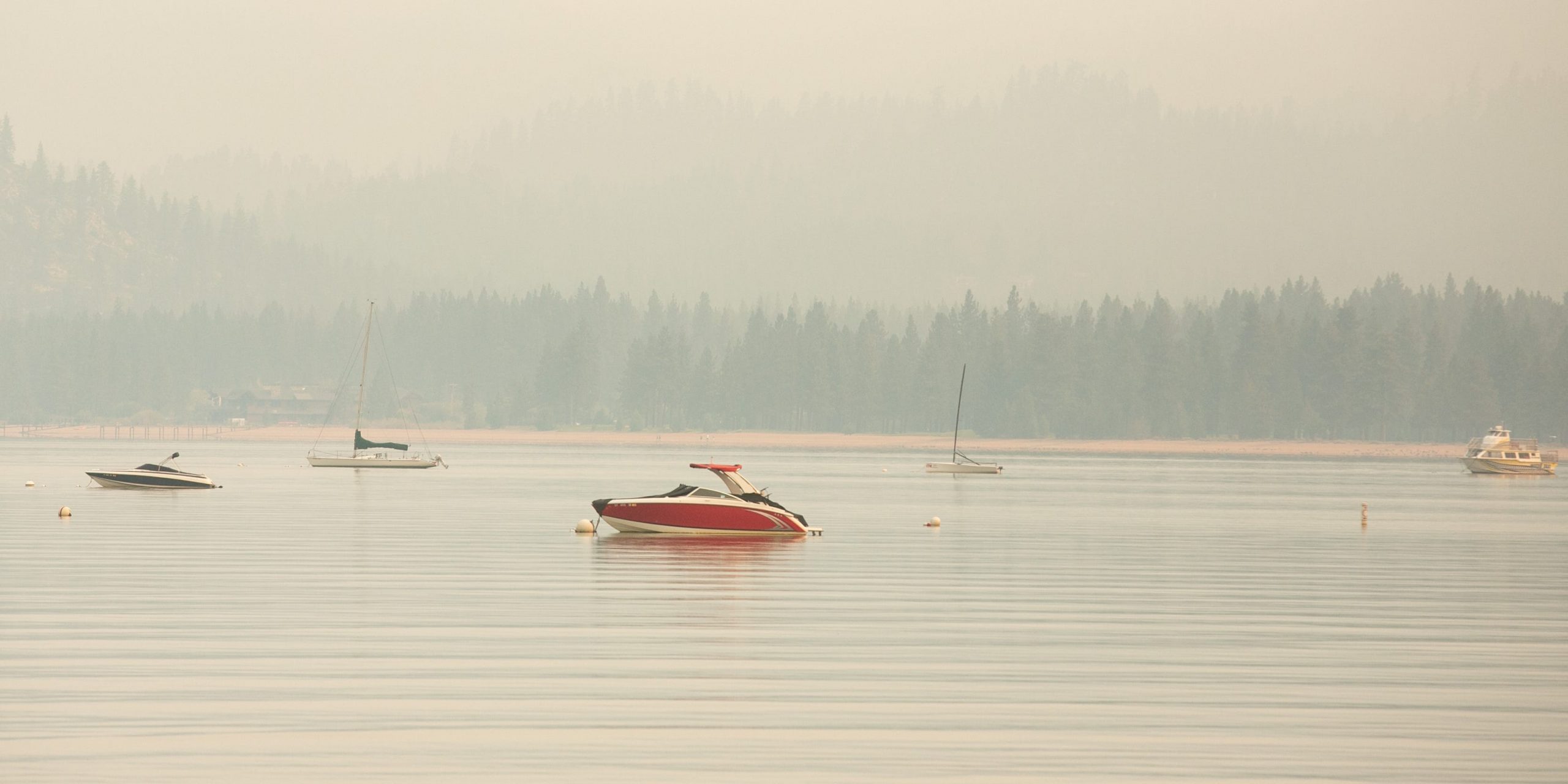 Boats sit on the cloudy waters of Lake Tahoe.