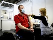 Een zorgmedewerker laat zich vaccineren tegen het coronavirus in de GGD-priklocatie in evenementencomplex Expo Houten.