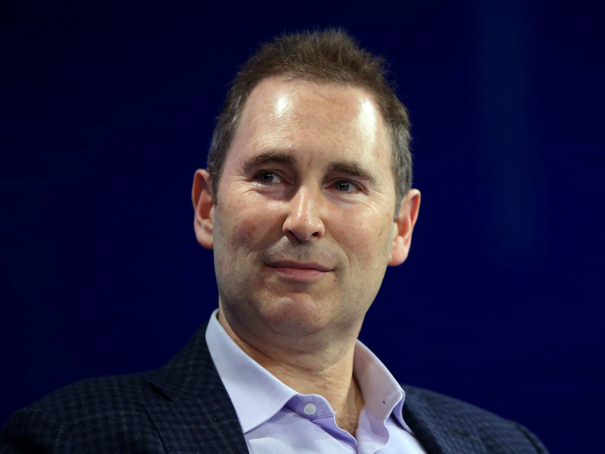 Headshot of Andy Jassy in front of a blue background