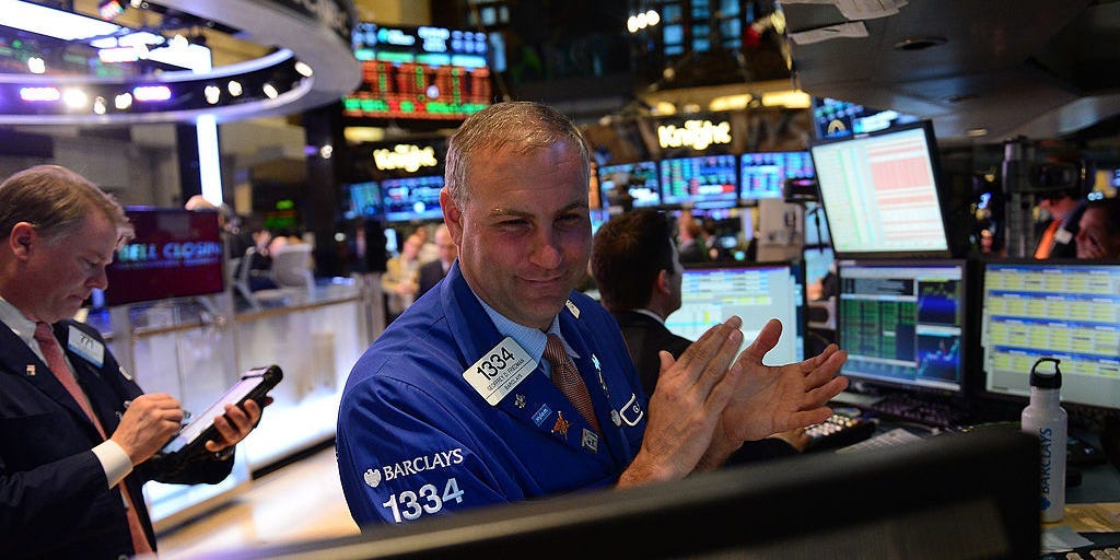 A stock trader claps at the end of trade at the New York Stock Exchange