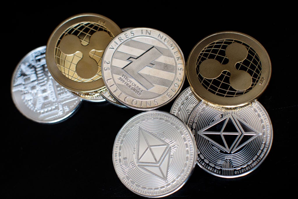 In this photo illustration of the litecoin, ripple and ethereum cryptocurrency 'altcoins' sit arranged for a photograph