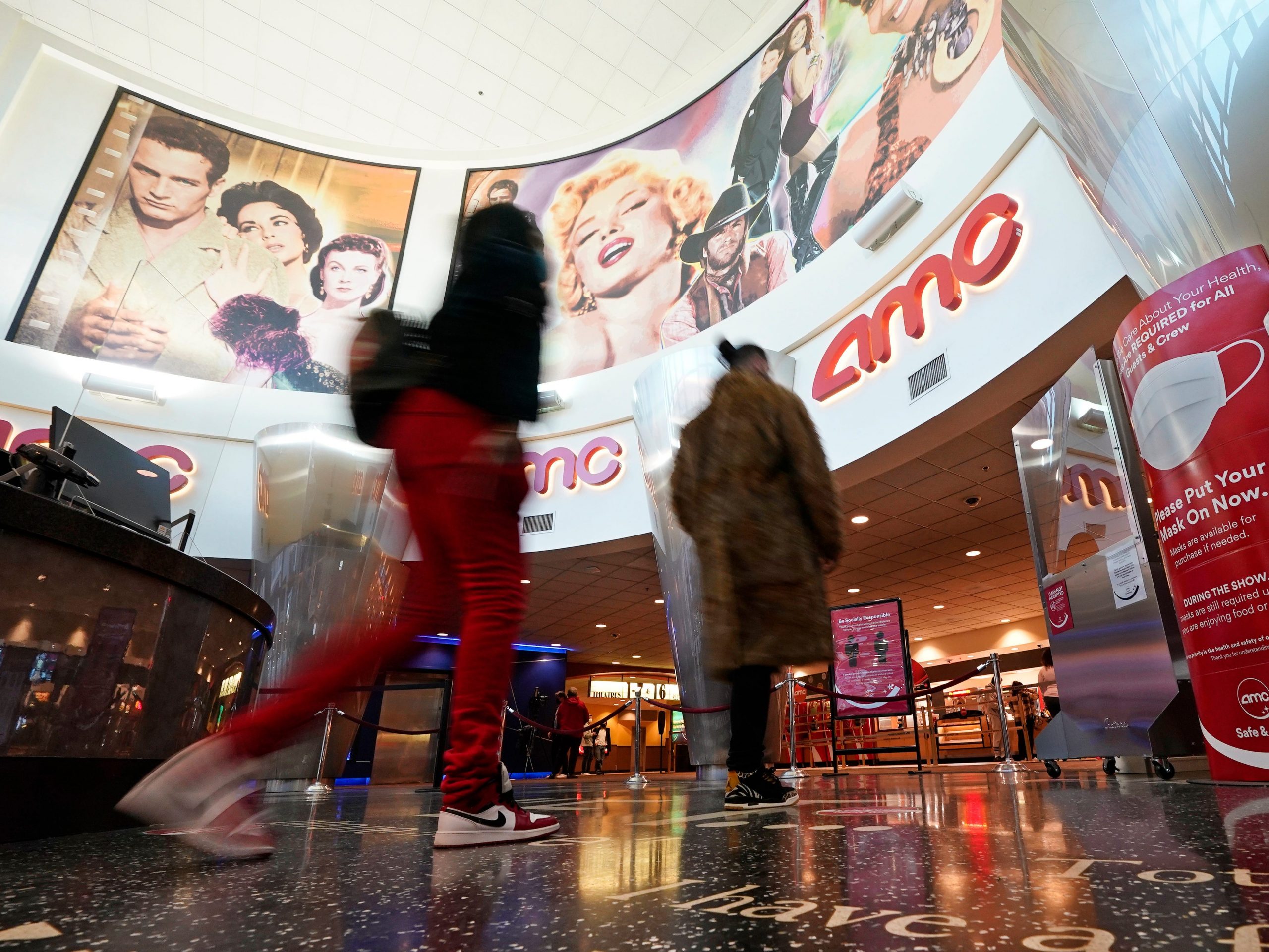 Movie patrons arrive to see a film at the AMC 16 theater in Burbank, California.