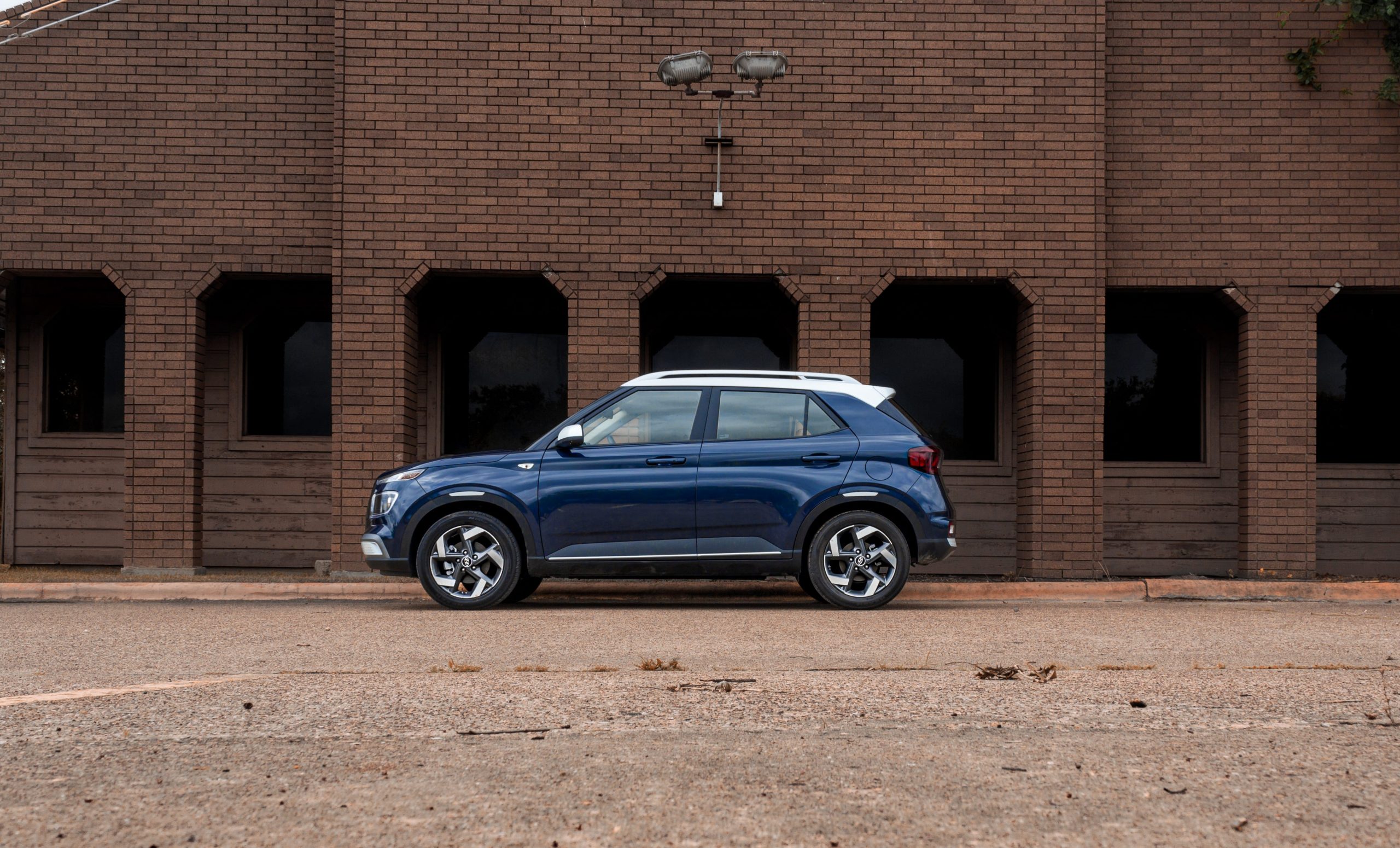 The blue Hyundai Venue Denim outside an orange brick building.