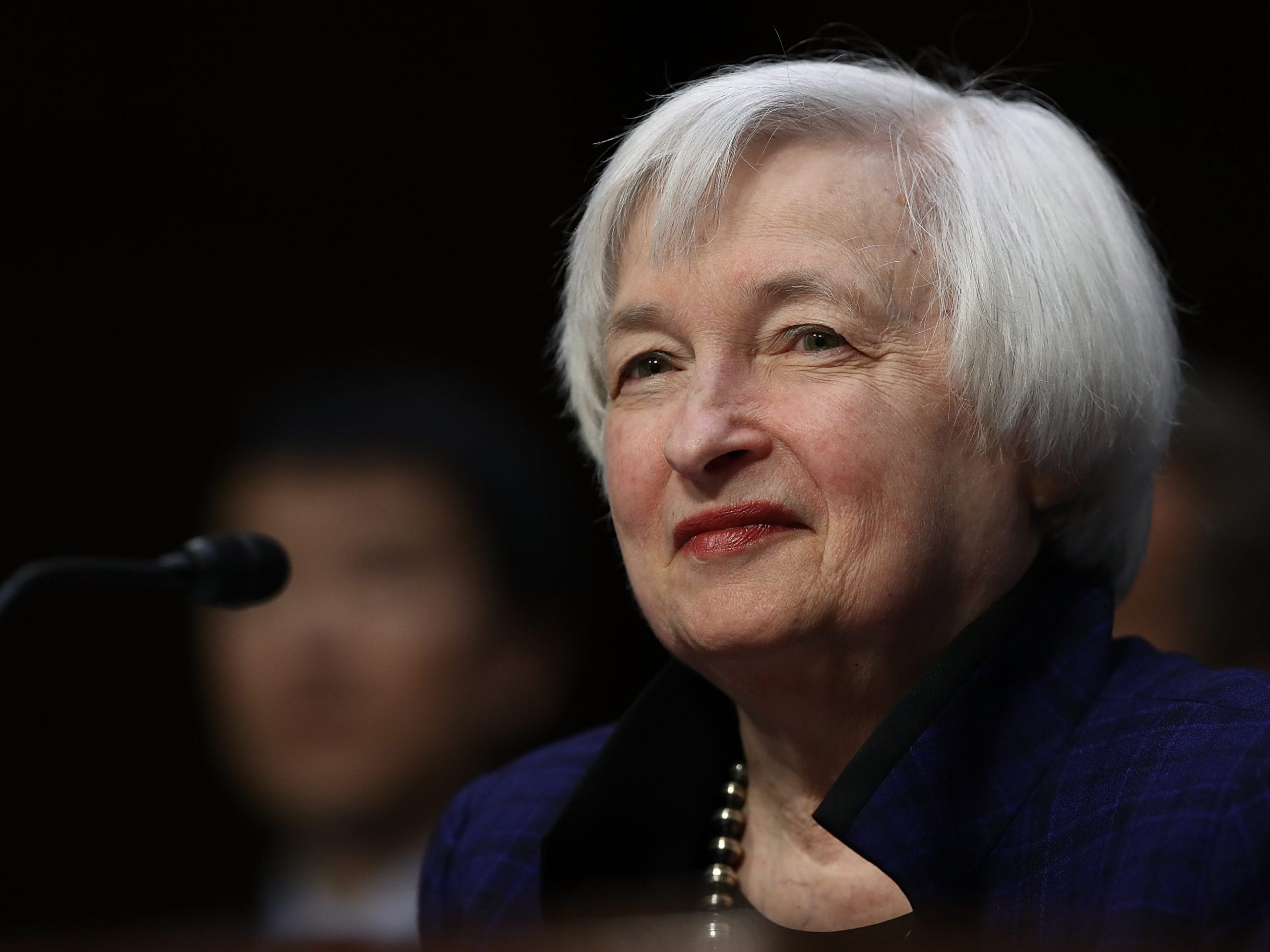 Janet Yellen smiling in front of a microphone