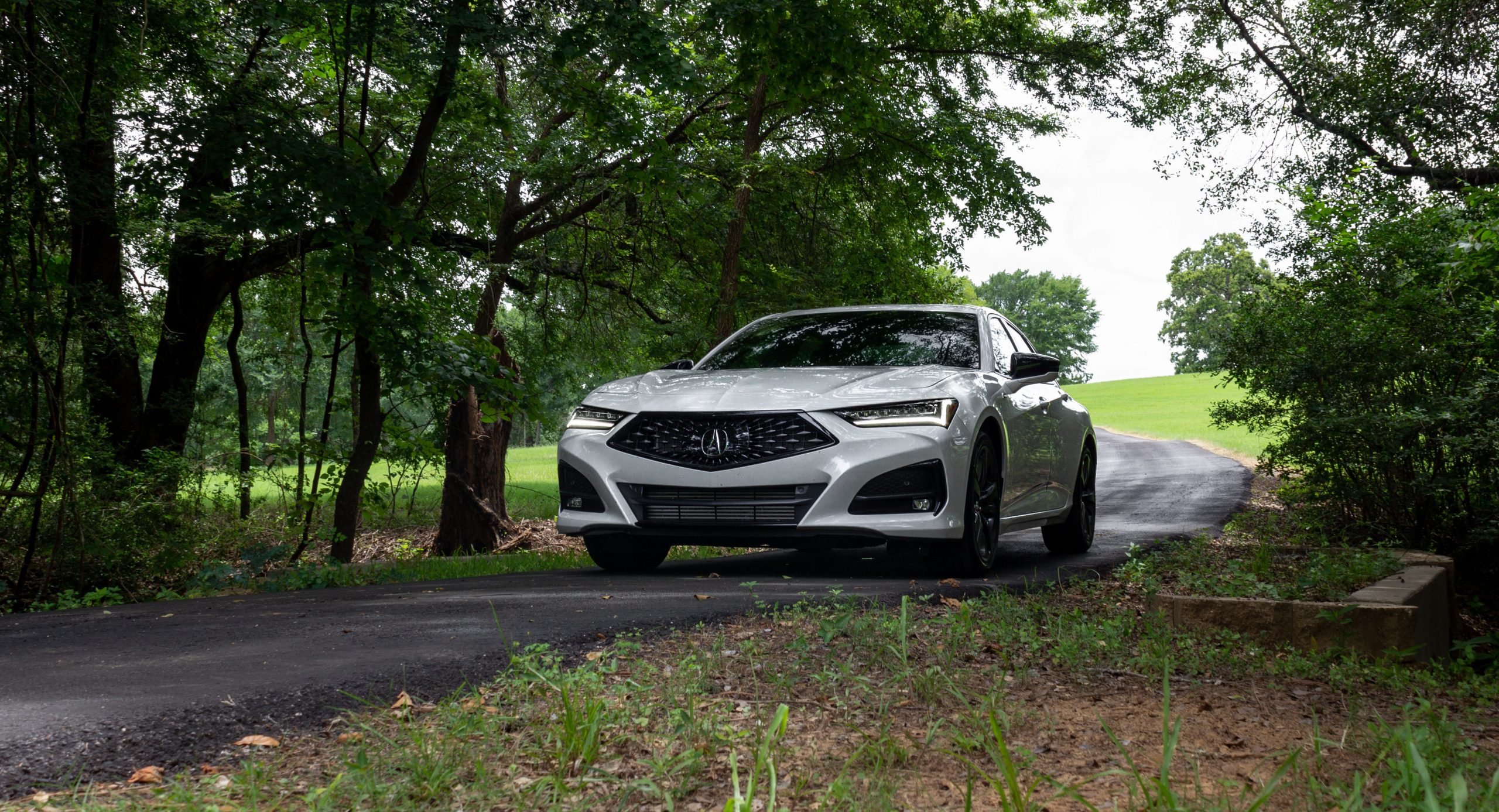 The 2021 Acura TLX A-Spec on a road in the trees.