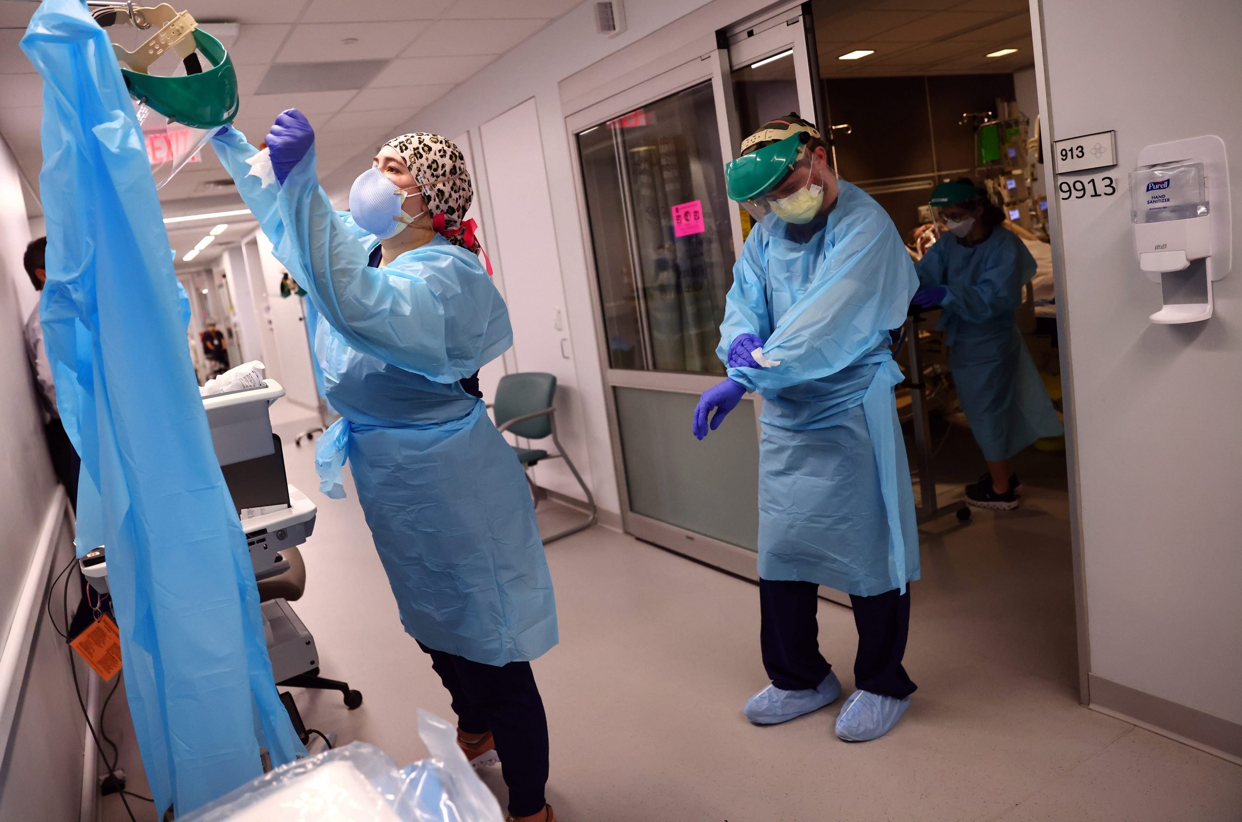 Clinicians depart a patient room after re-positioning a COVID-19 patient into the supine position in the Intensive Care Unit (ICU) at Lake Charles Memorial Hospital on August 10, 2021 in Lake Charles, Louisiana.