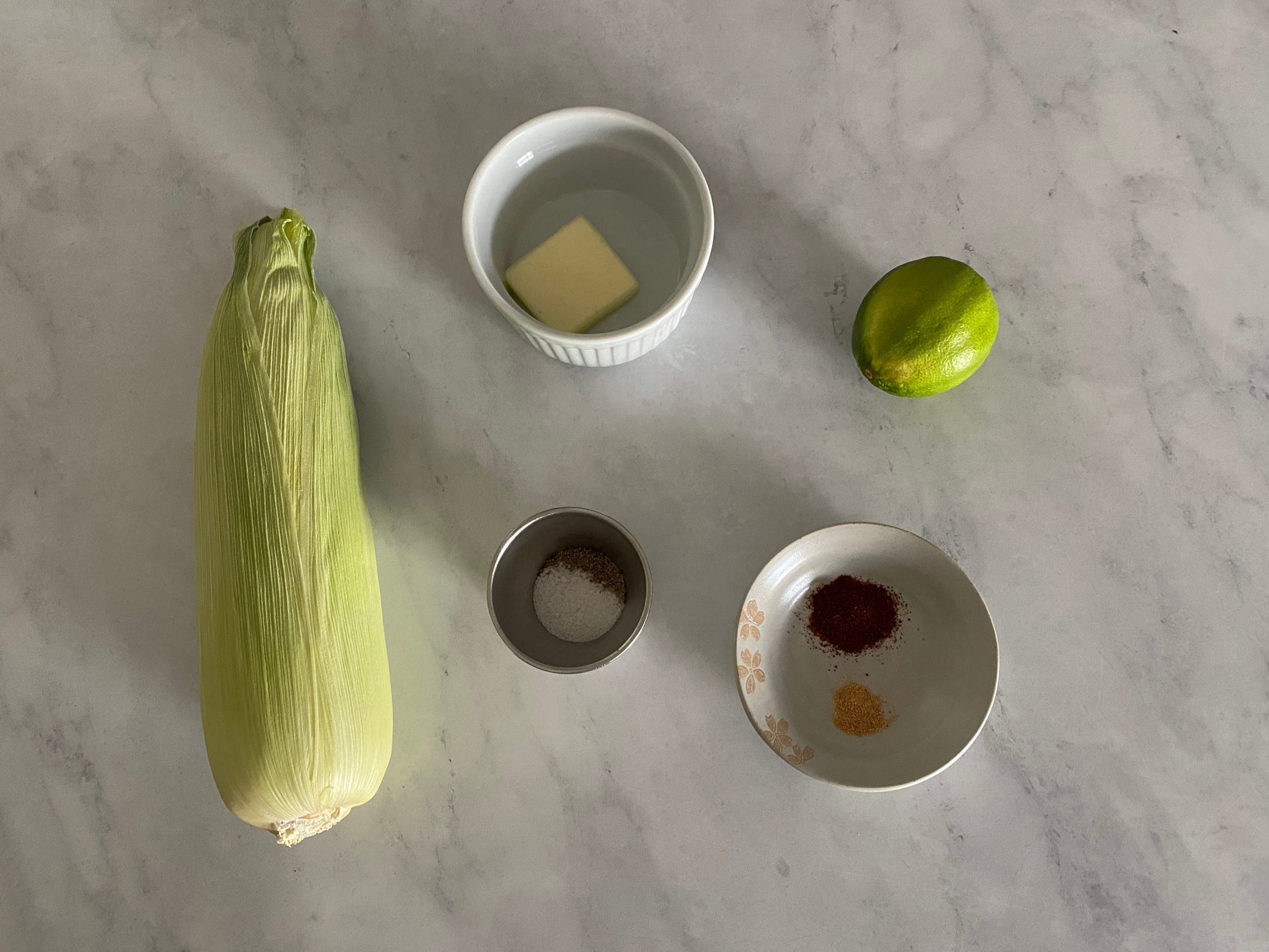 Corn, bitter, chili, and spices on a table.