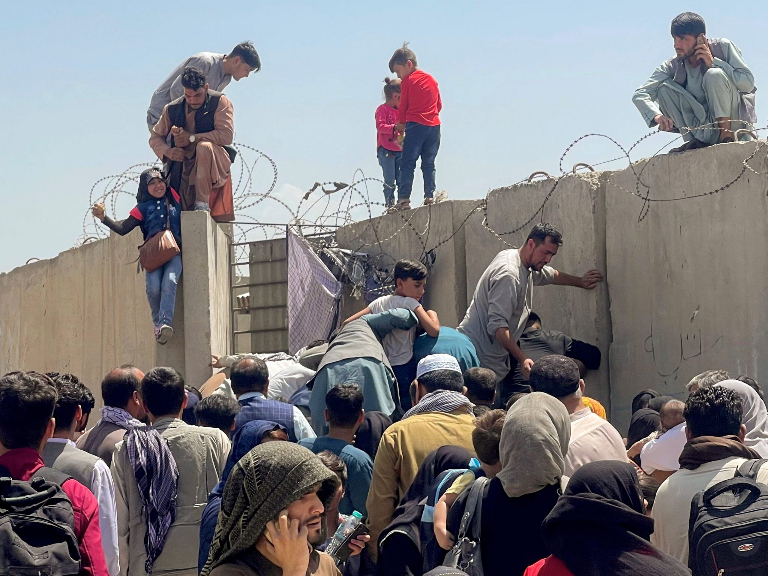 A man pulls a girl to get inside Hamid Karzai International Airport in Kabul, Afghanistan August 16, 2021