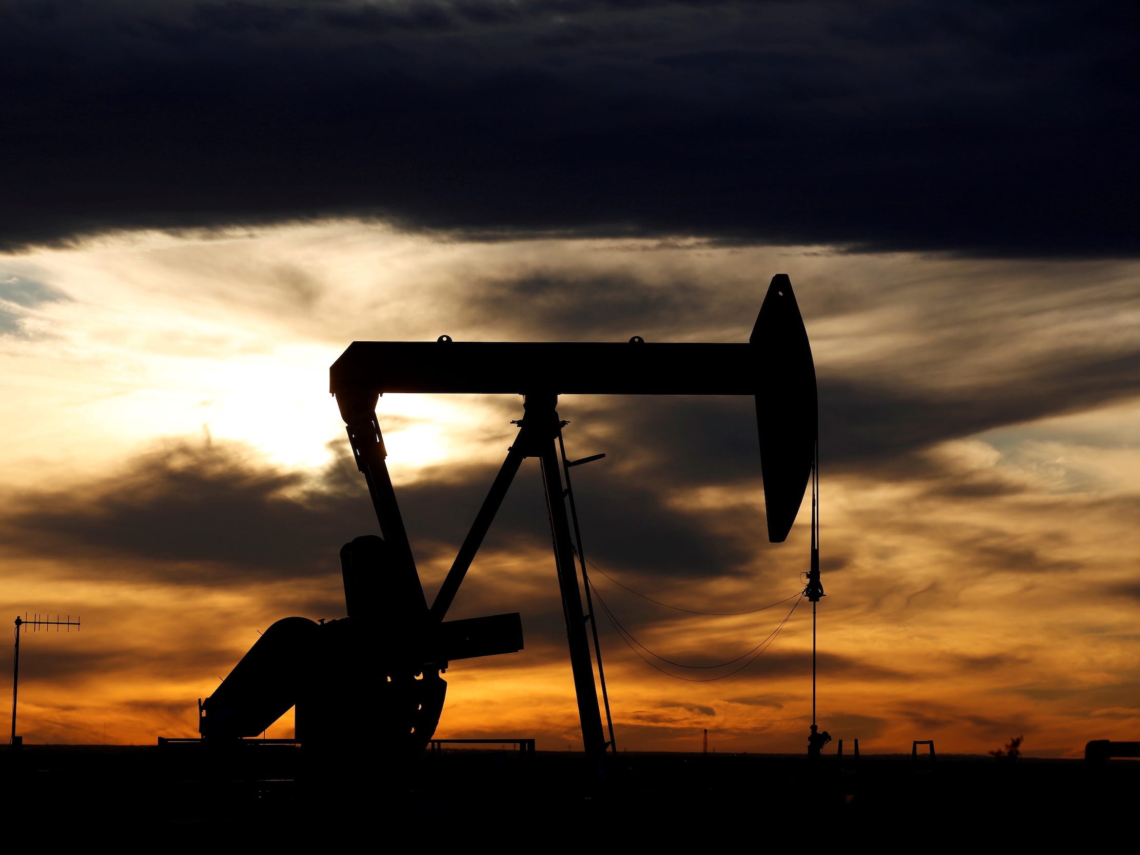crude oil pump jack in texas field sunset backdrop