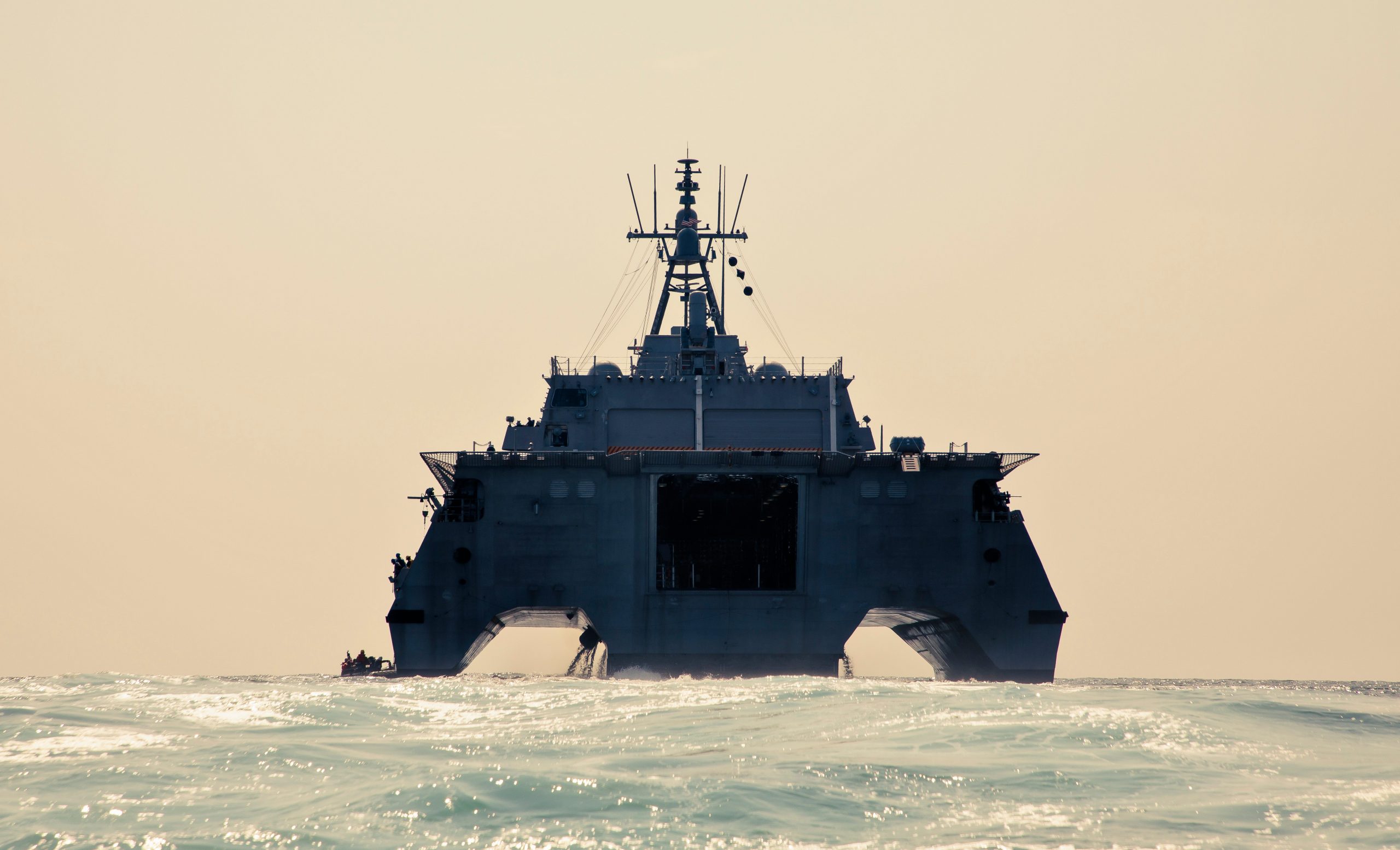 The rear of a navy ship as seen out in the water
