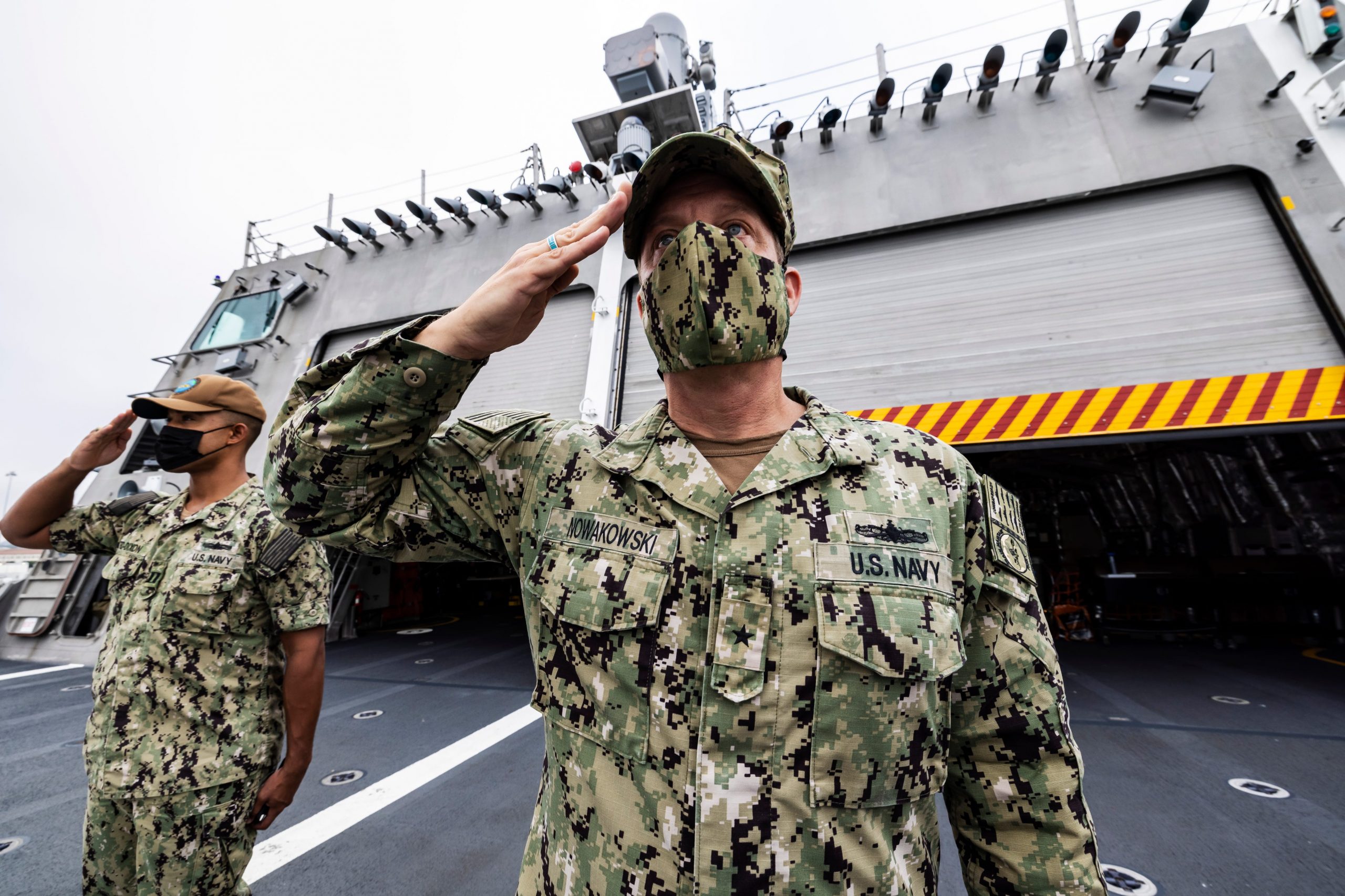 Two men in uniform are seen saluting