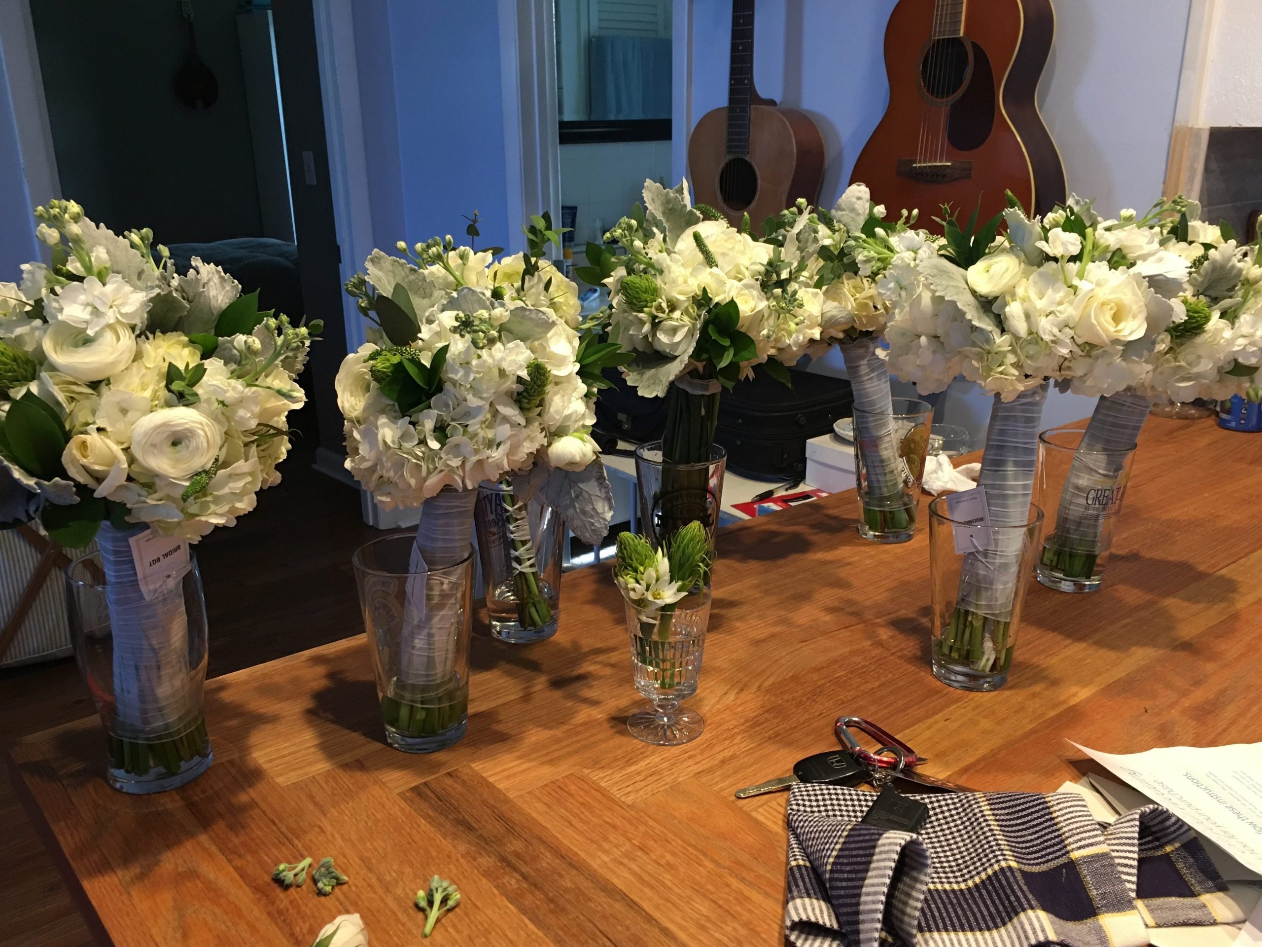 White roses arranged on a wooden table.