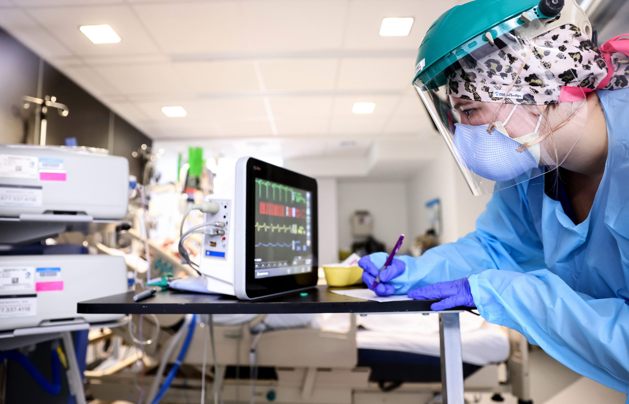 An ICU clinician writes down a patient's vitals