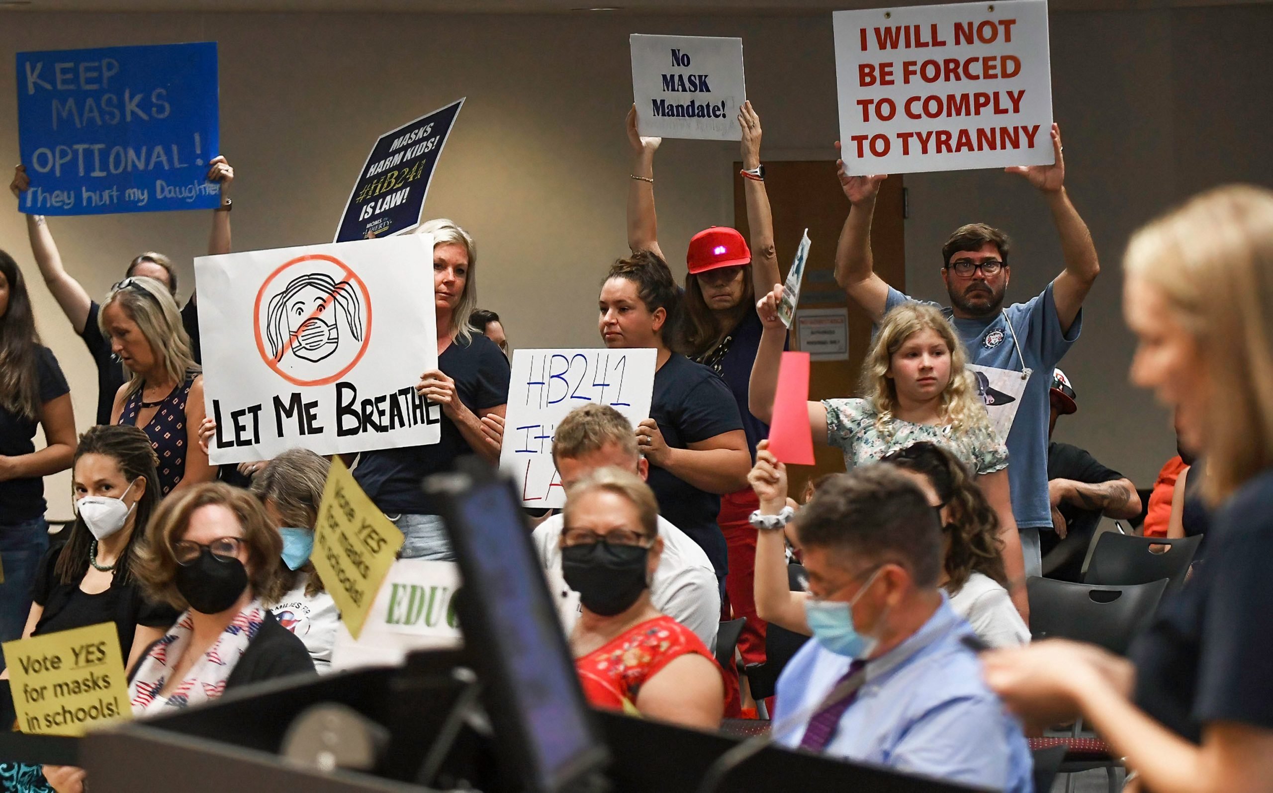 People demonstrate at an emergency meeting of the Brevard County, Florida School Board in Viera to discuss whether face masks in local schools should be mandatory.