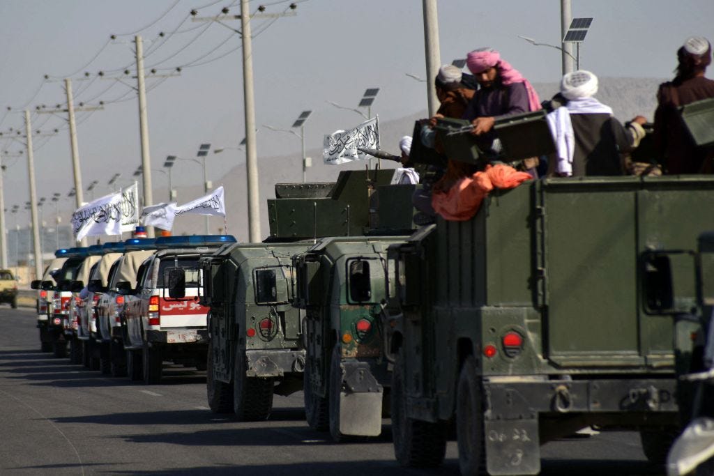 Taliban fighters stand on an armoured vehicle as they parade along a road to celebrate after the US pulled all its troops out of Afghanistan, in Kandahar on September 1, 2021 following the Talibans military takeover of the country.