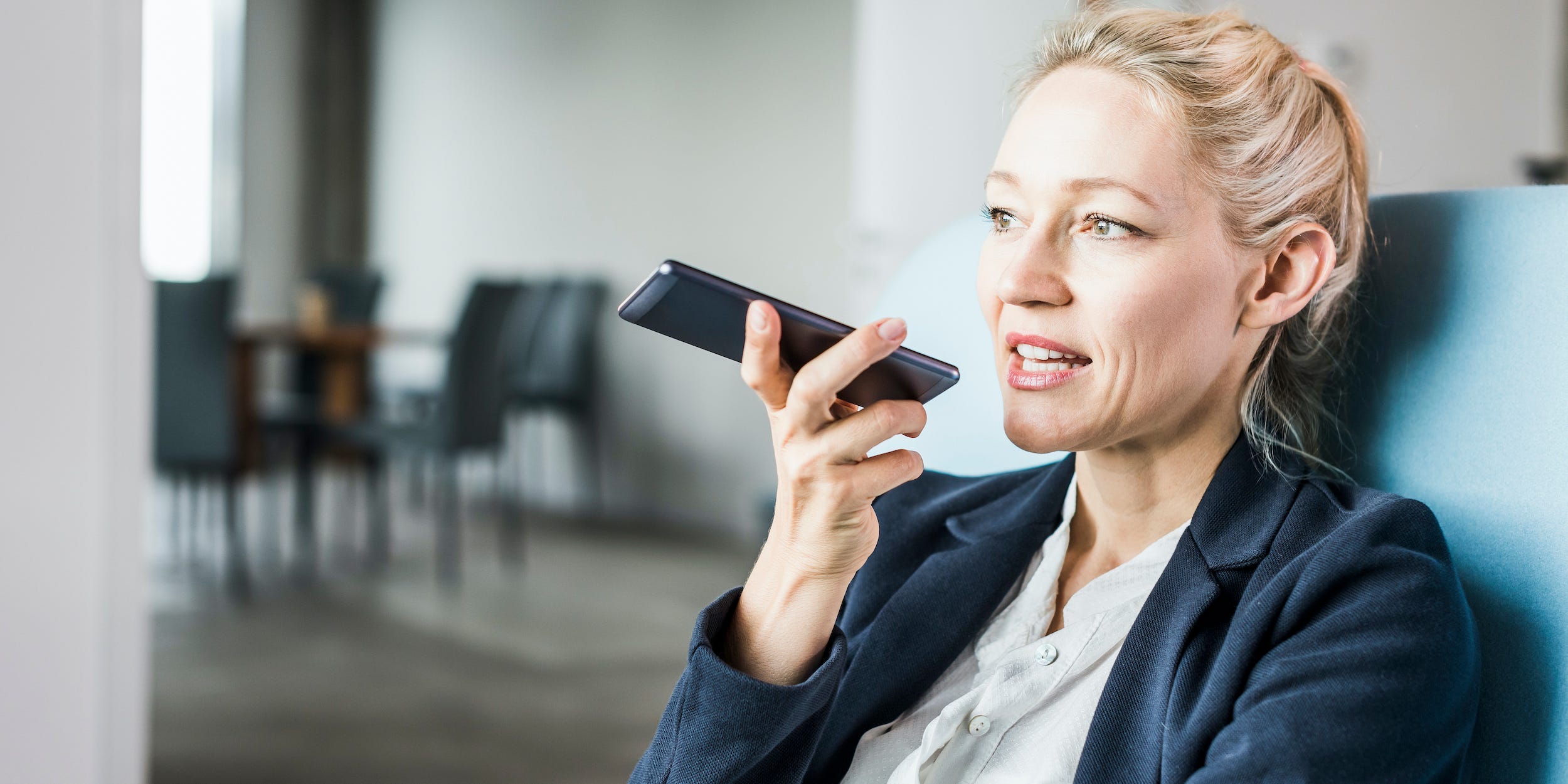 business professional talking into smartphone at office