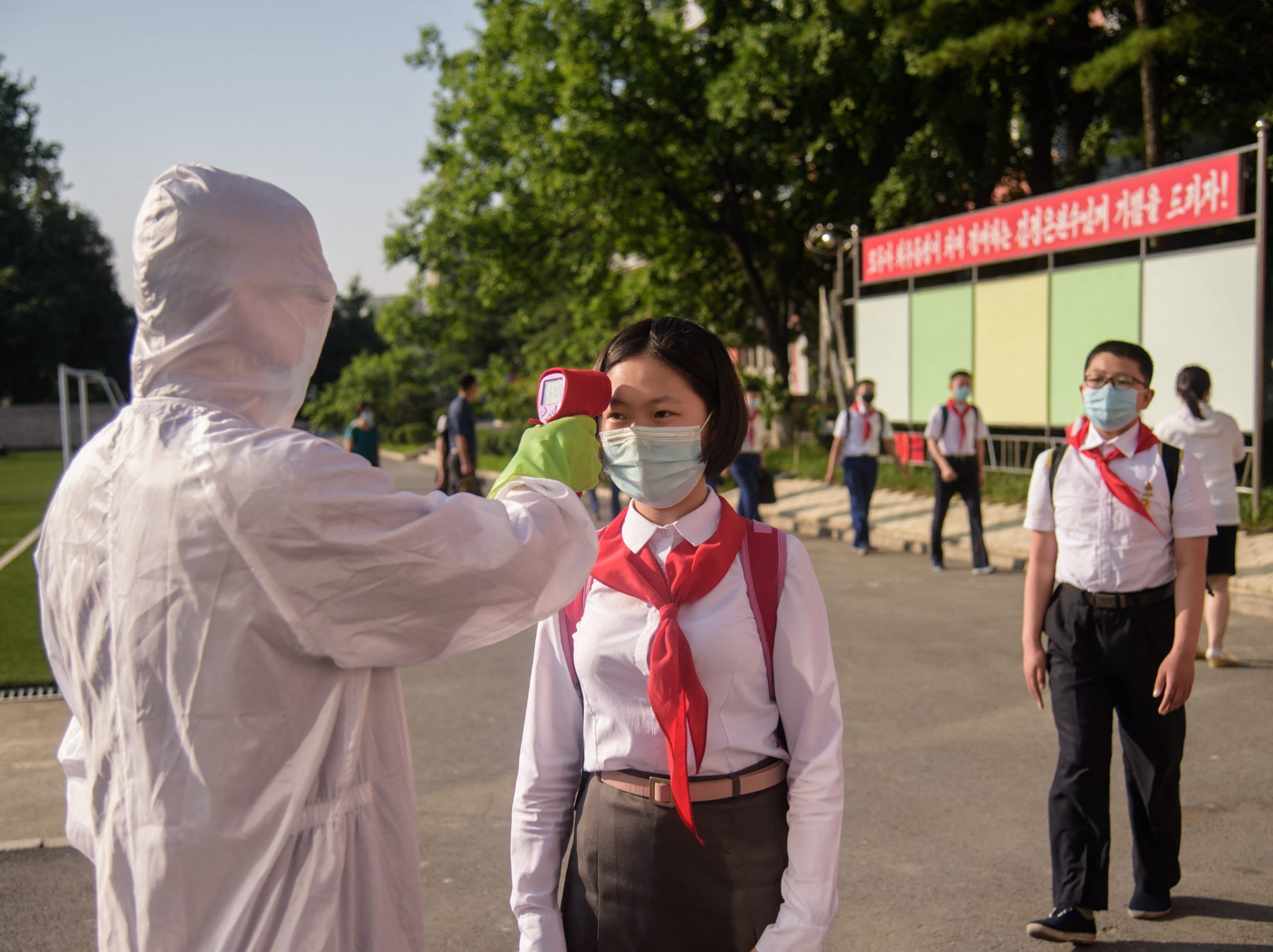 A pupil has her temperature taken as part of anti Covid-19 procedures before entering the Pyongyang Secondary School No. 1 in Pyongyang on June 22, 2021.