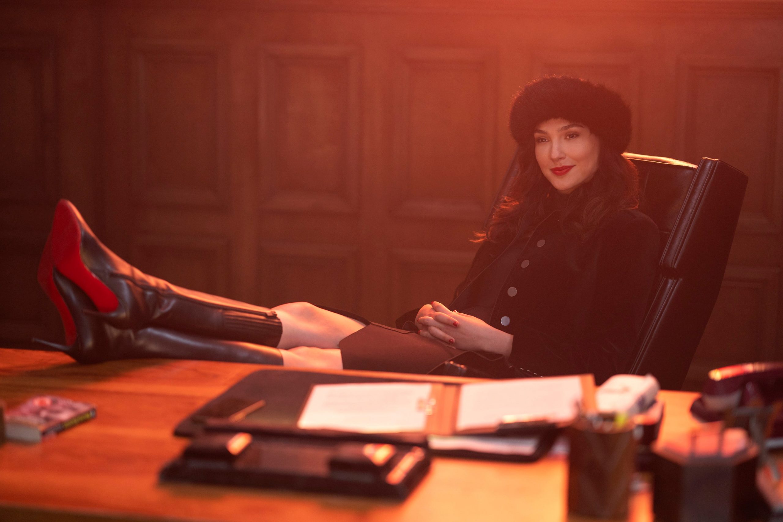 Gal Gadot sitting behind a desk