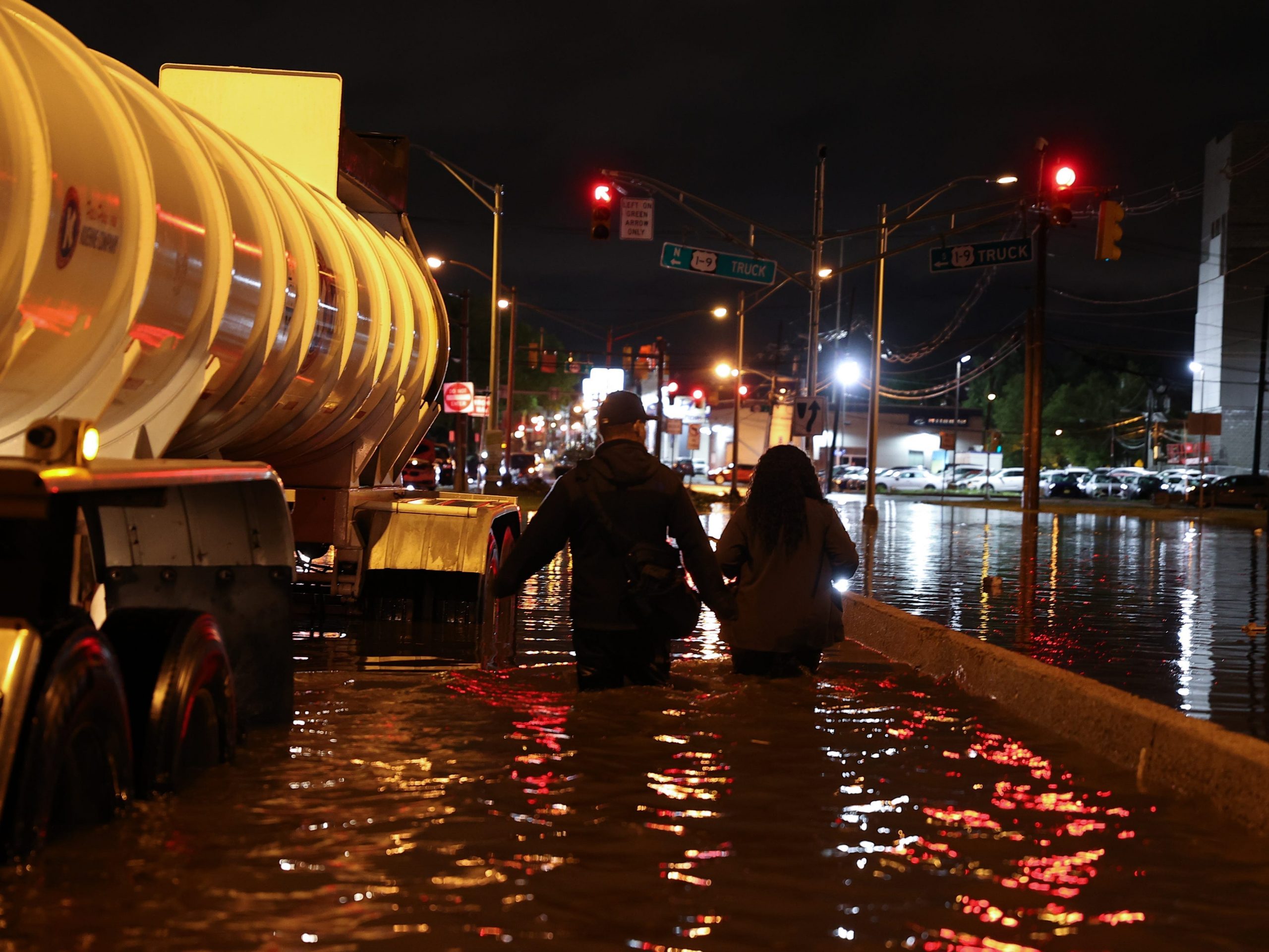 Two people walk through flooded streets in New Jersey.
