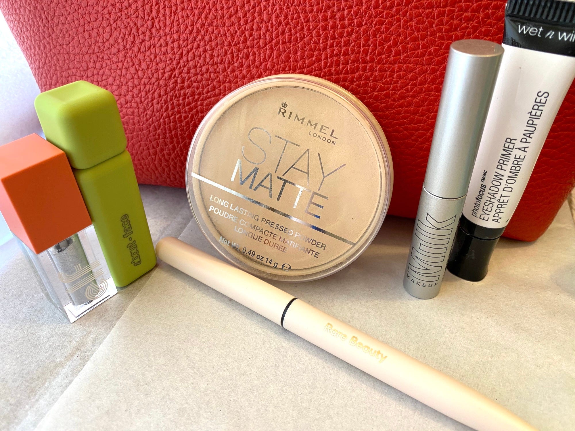 Eye makeup placed in front of a red makeup bag.