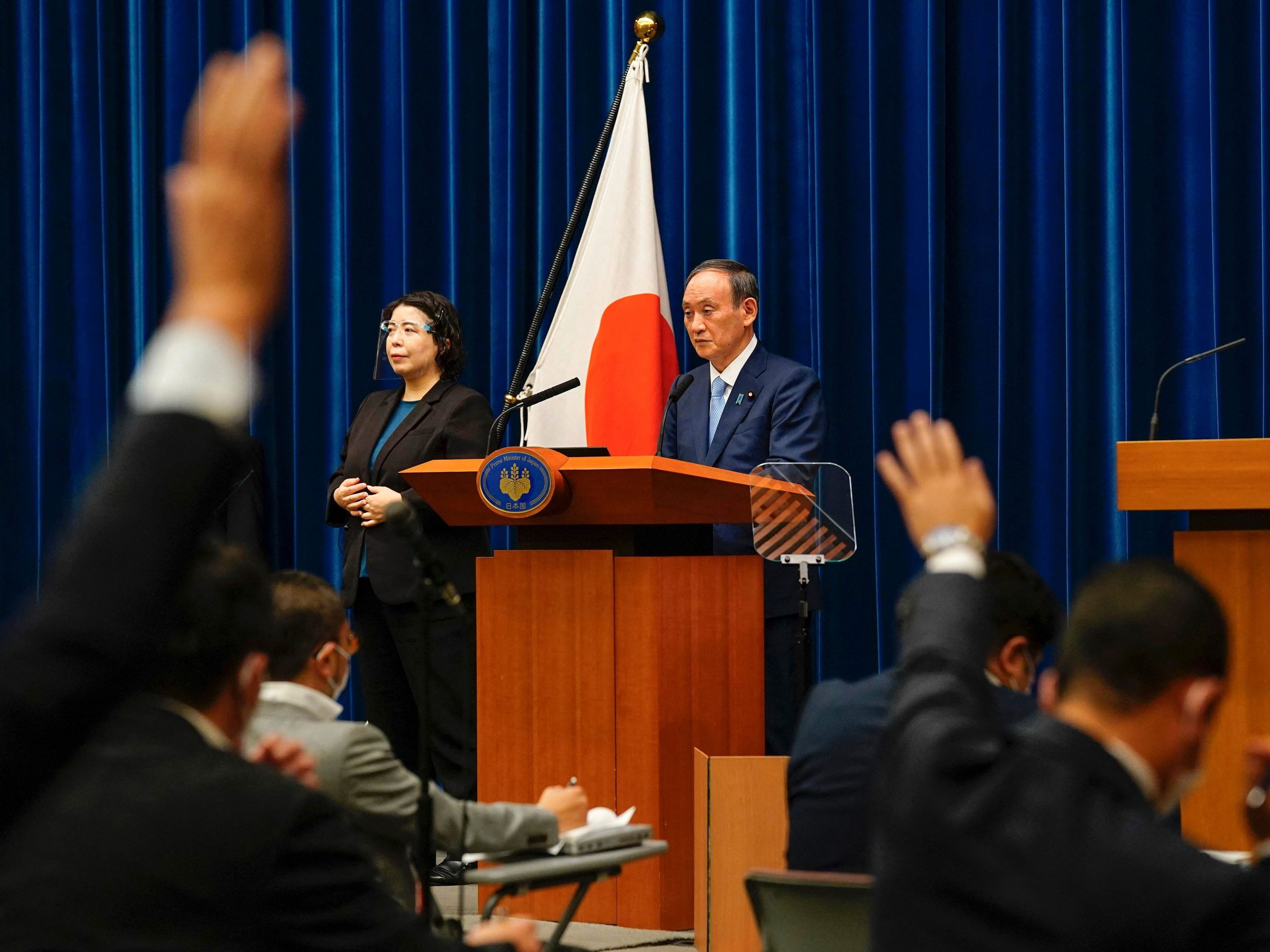 Japan's Prime Minister Yoshihide Suga (C) waits to answer journalists' questions during a news conference at his official residence in Tokyo on August 17, 2021.