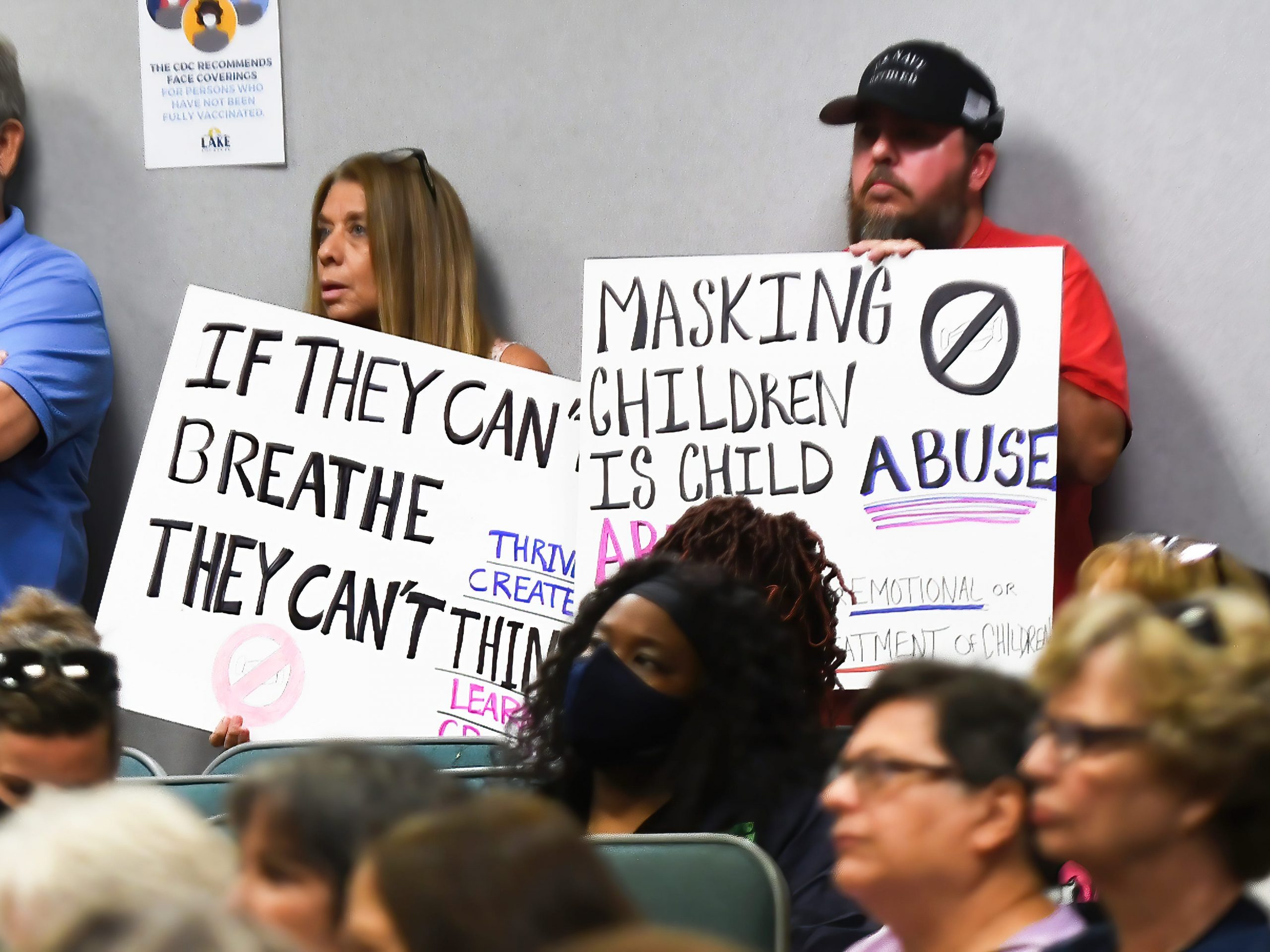 People demonstrate with placards at a special meeting of the Lake County, Florida School Board in Tavares to discuss whether face masks should be mandatory in local schools, September 02, 2021.