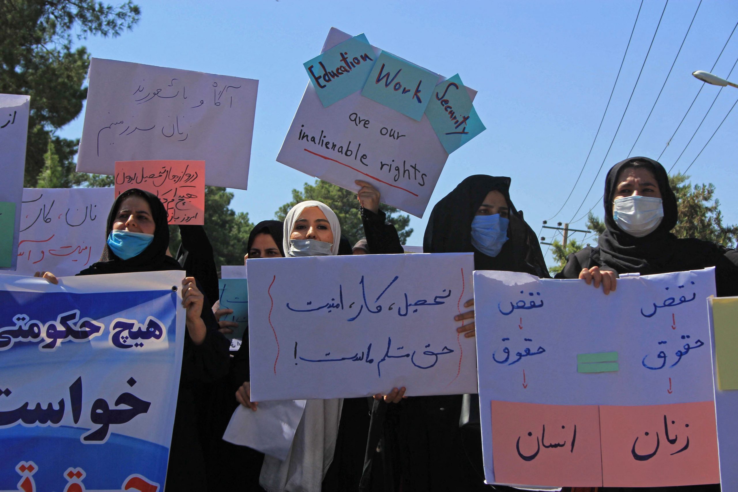 Afghan women hold placards as they take part in a protest in Herat on September 2, 2021