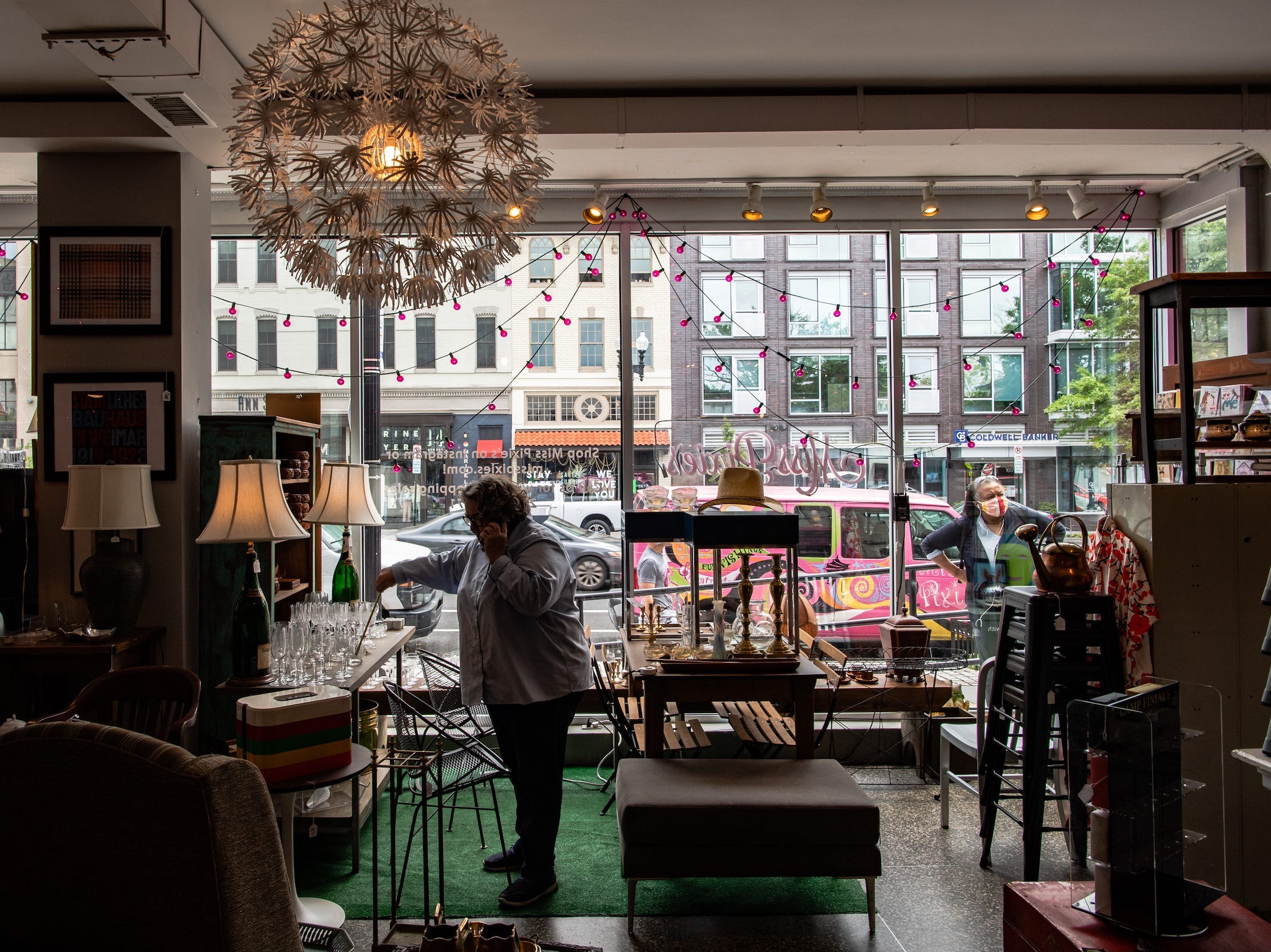 Woman talks on phone inside vintage furniture store