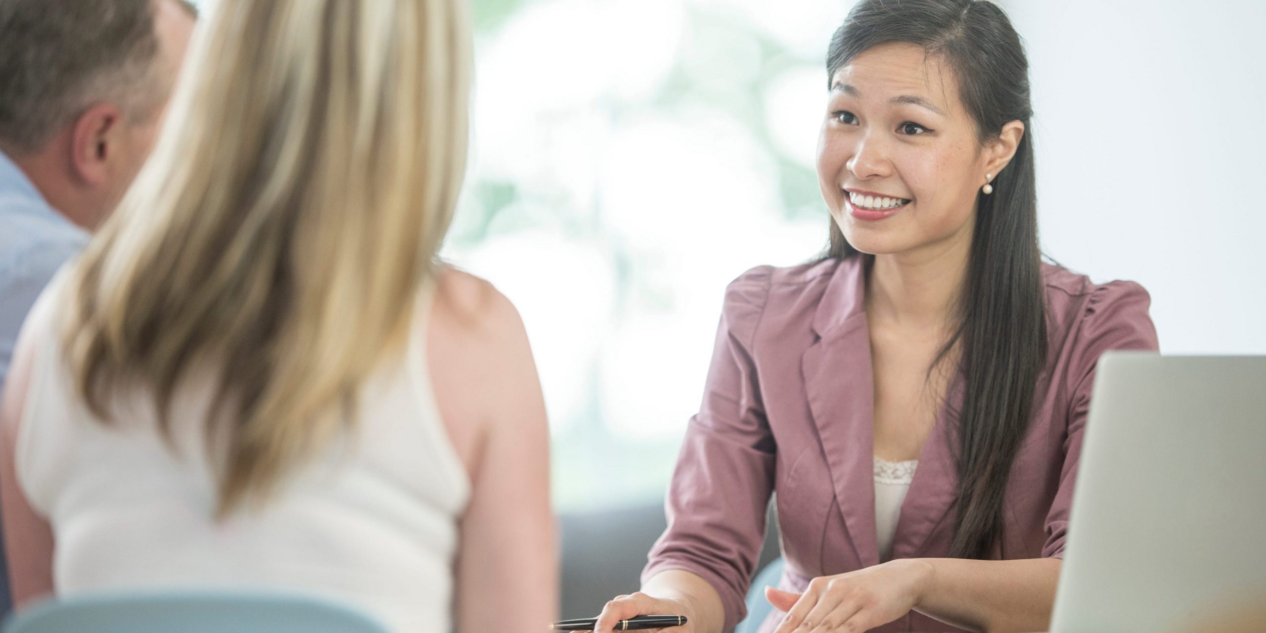 A financial planner meeting with a husband and wife to discuss their financial savings, accounts, and loans.