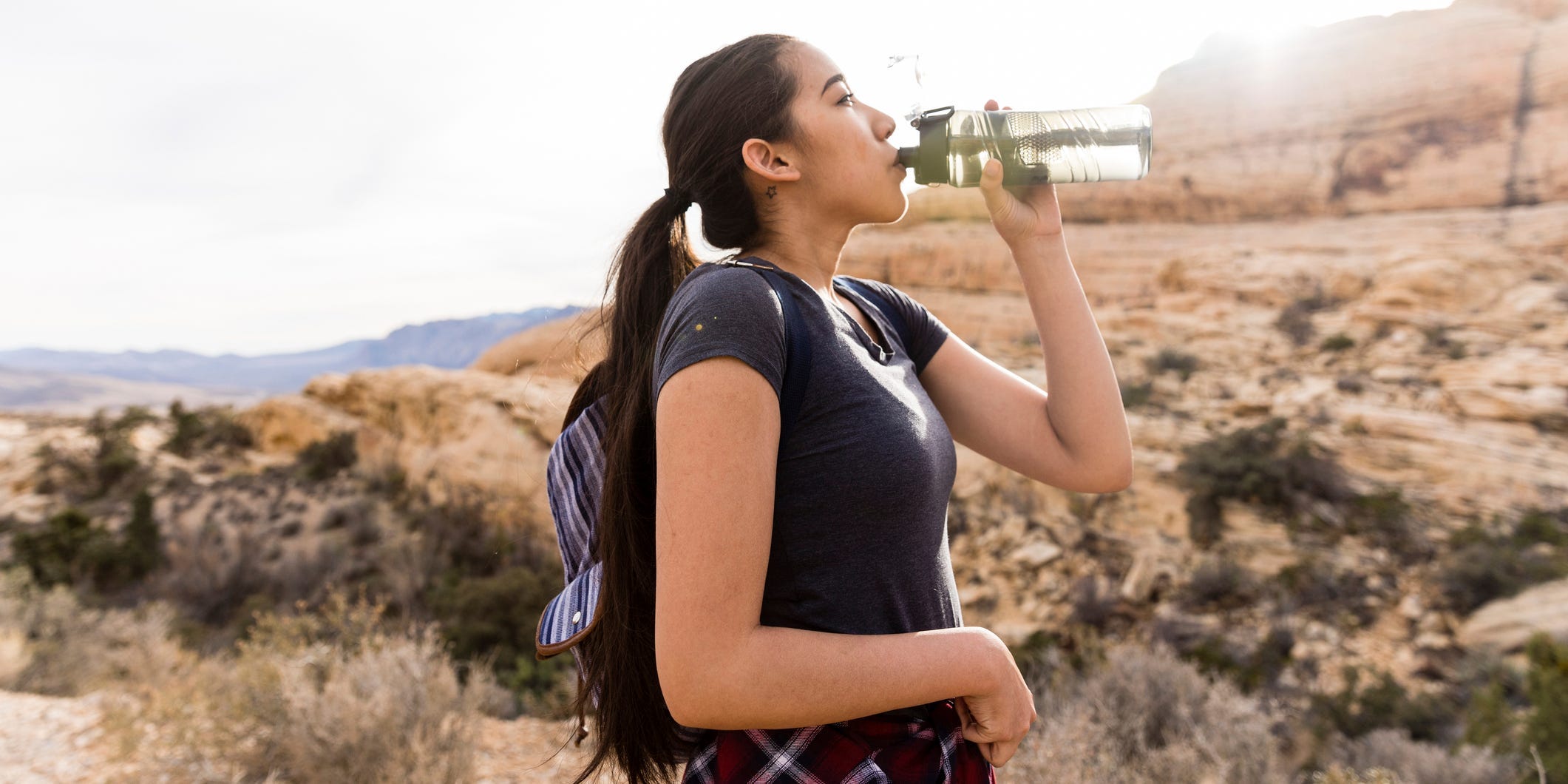 woman drinking water in desert