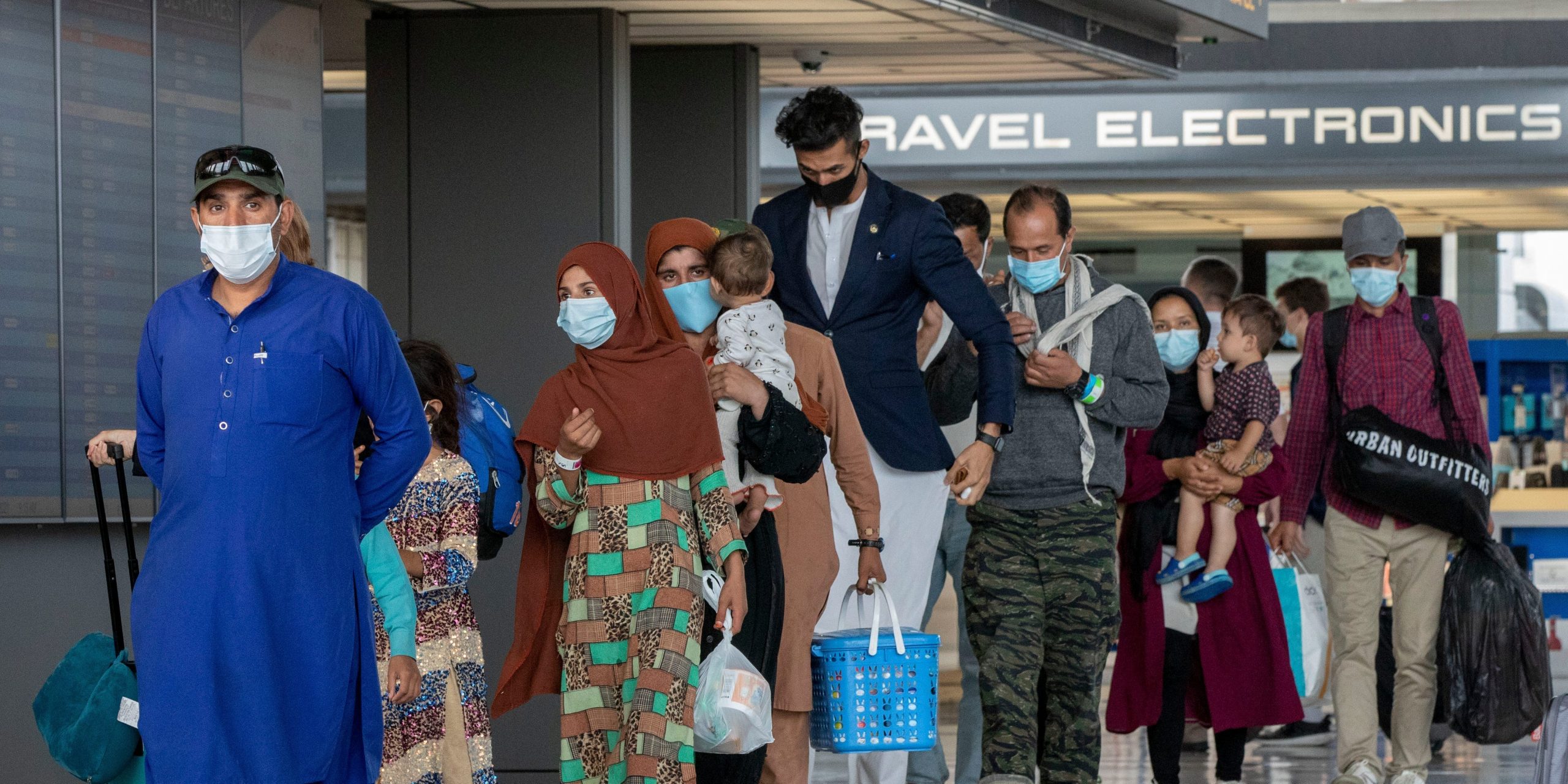 In this Tuesday, Aug. 31, 2021, file photo, families evacuated from Kabul, Afghanistan, walk through the terminal to board a bus after they arrived at Washington Dulles International Airport, in Chantilly, Va. U.S. religious groups of many faiths are gearing up to assist the thousands of incoming refugees.