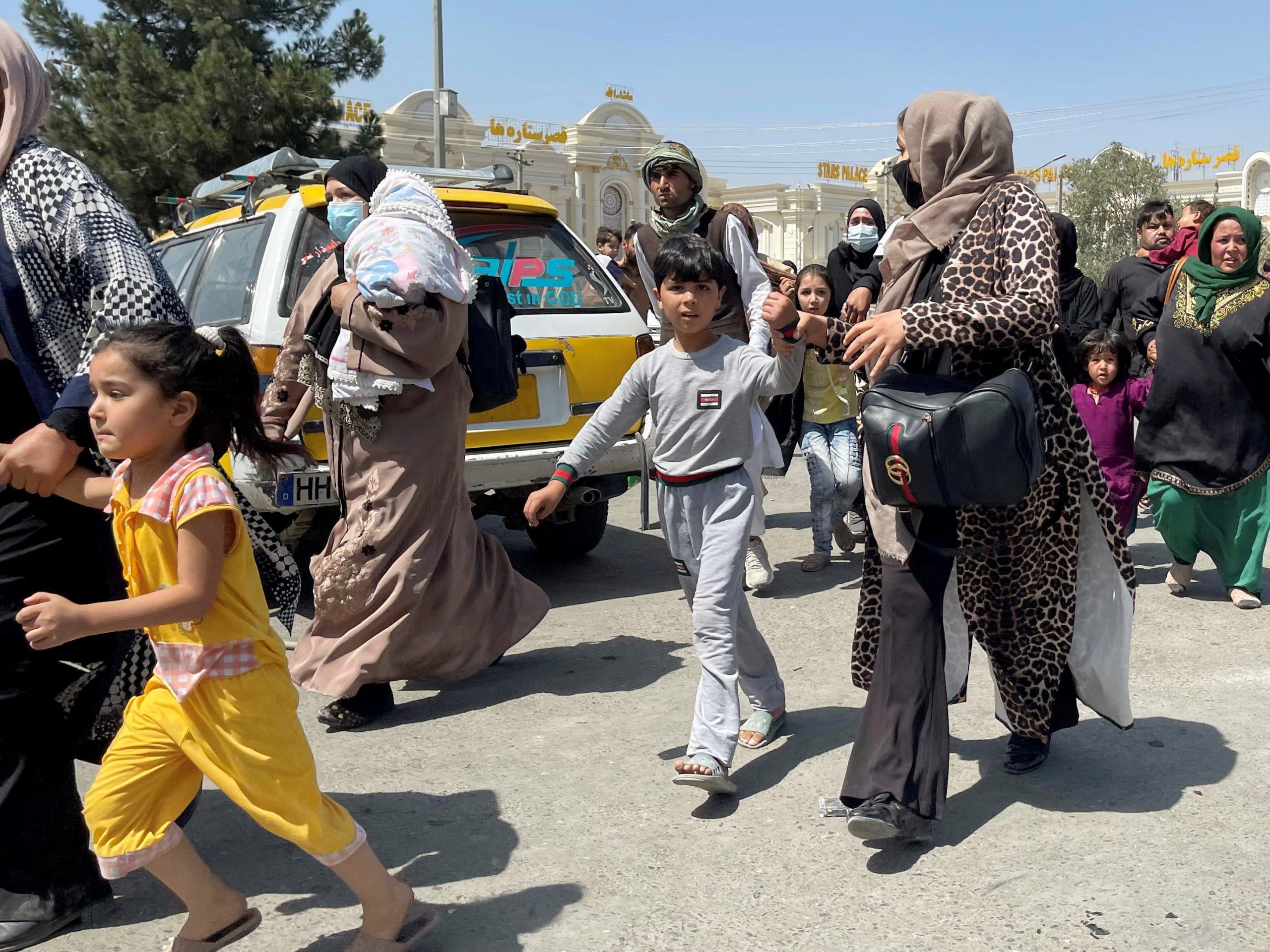 Women with their children try to get inside Hamid Karzai International Airport in Kabul, Afghanistan August 16, 2021.