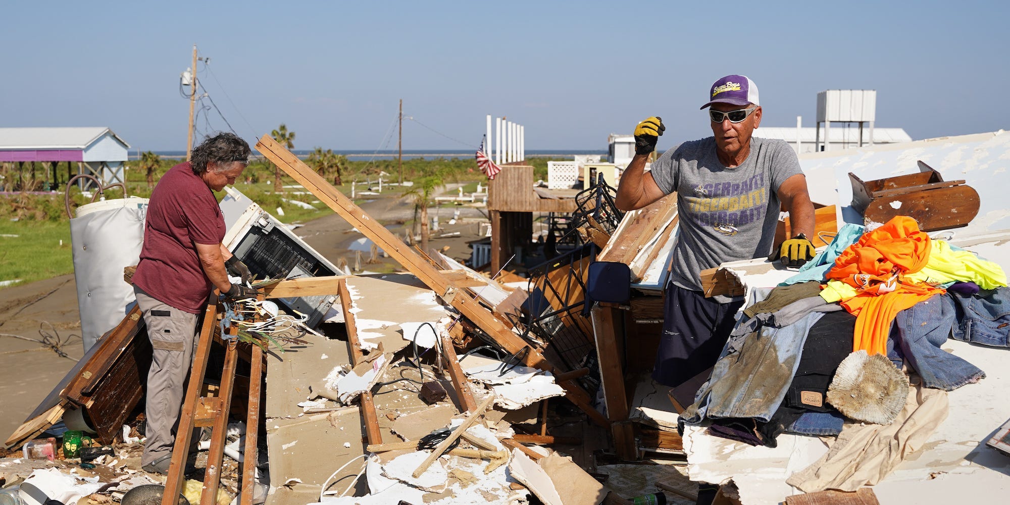 Corbert Barrios, right, and his wife, Anna Barrios, clean up their storm-damaged house after Hurricane Ida on September 4, 2021 in Grand Isle, Louisiana.