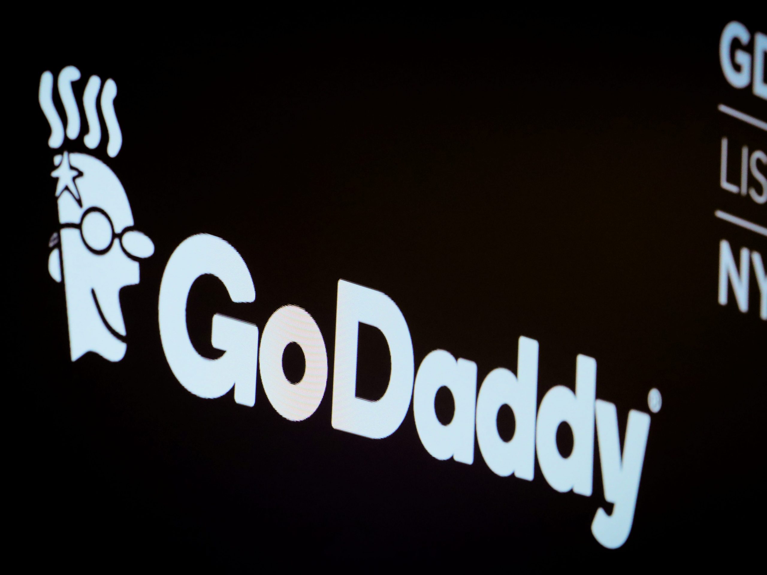FILE PHOTO: The company logo and ticker for GoDaddy Inc. is displayed on a screen on the floor of the New York Stock Exchange (NYSE) in New York, U.S., March 4, 2019. REUTERS/Brendan McDermid