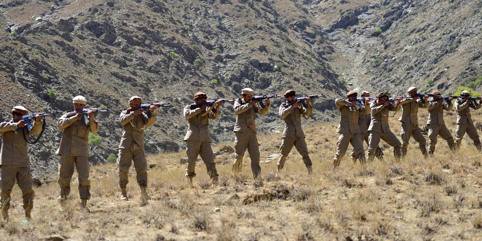 Afghan resistance fighters with guns on a mountain
