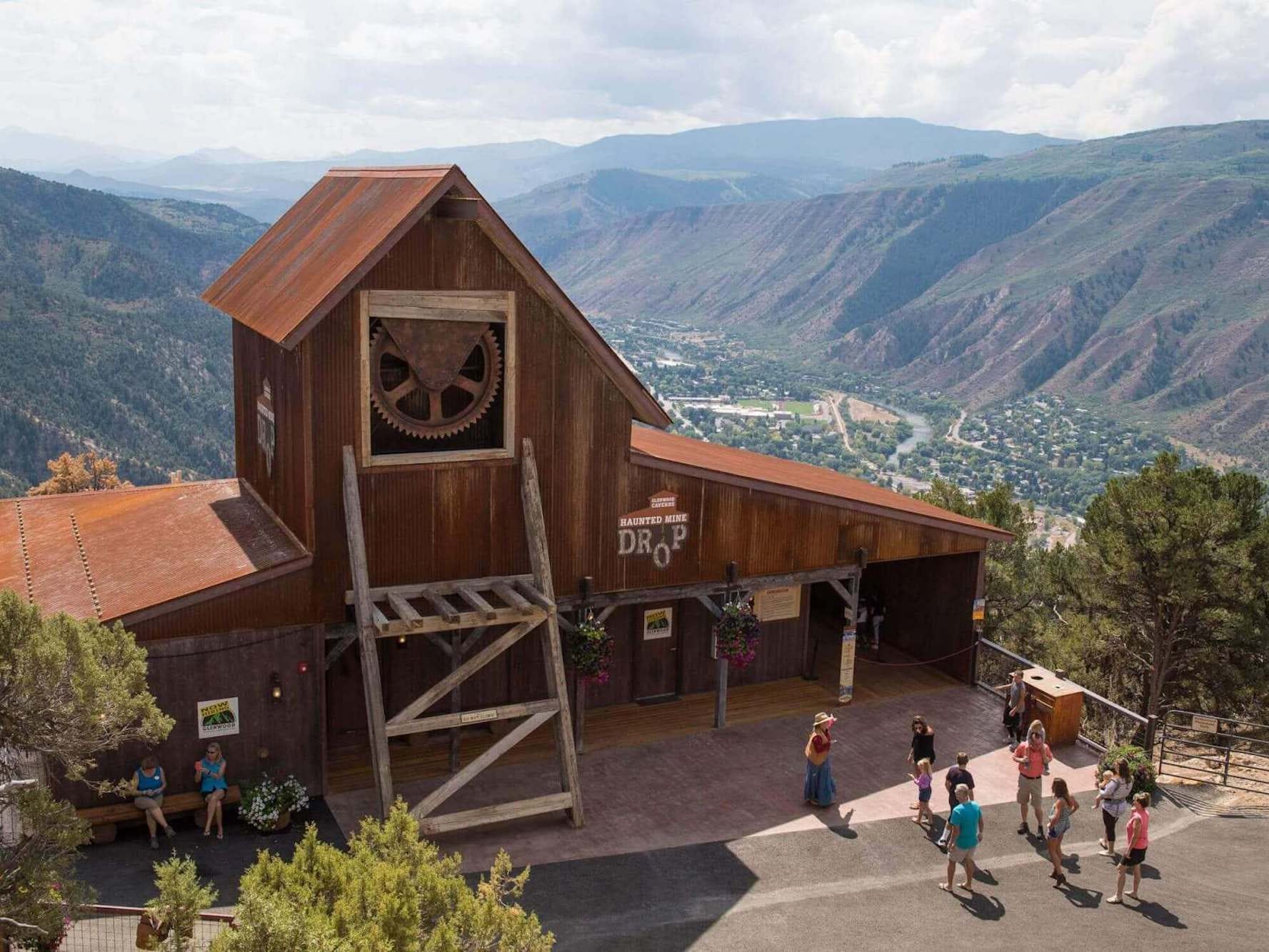 The building housing the "Haunted Mine Drop" ride at Glenwood Caverns amusement park, with mountains in the background