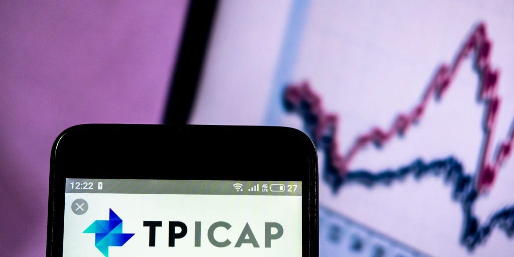 TP ICAP logo on phone in front of stock chart