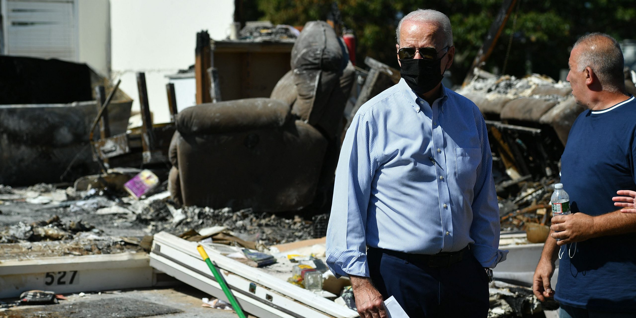 US President Joe Biden stands in front of a damaged home in Manville, New Jersey on September 7, 2021