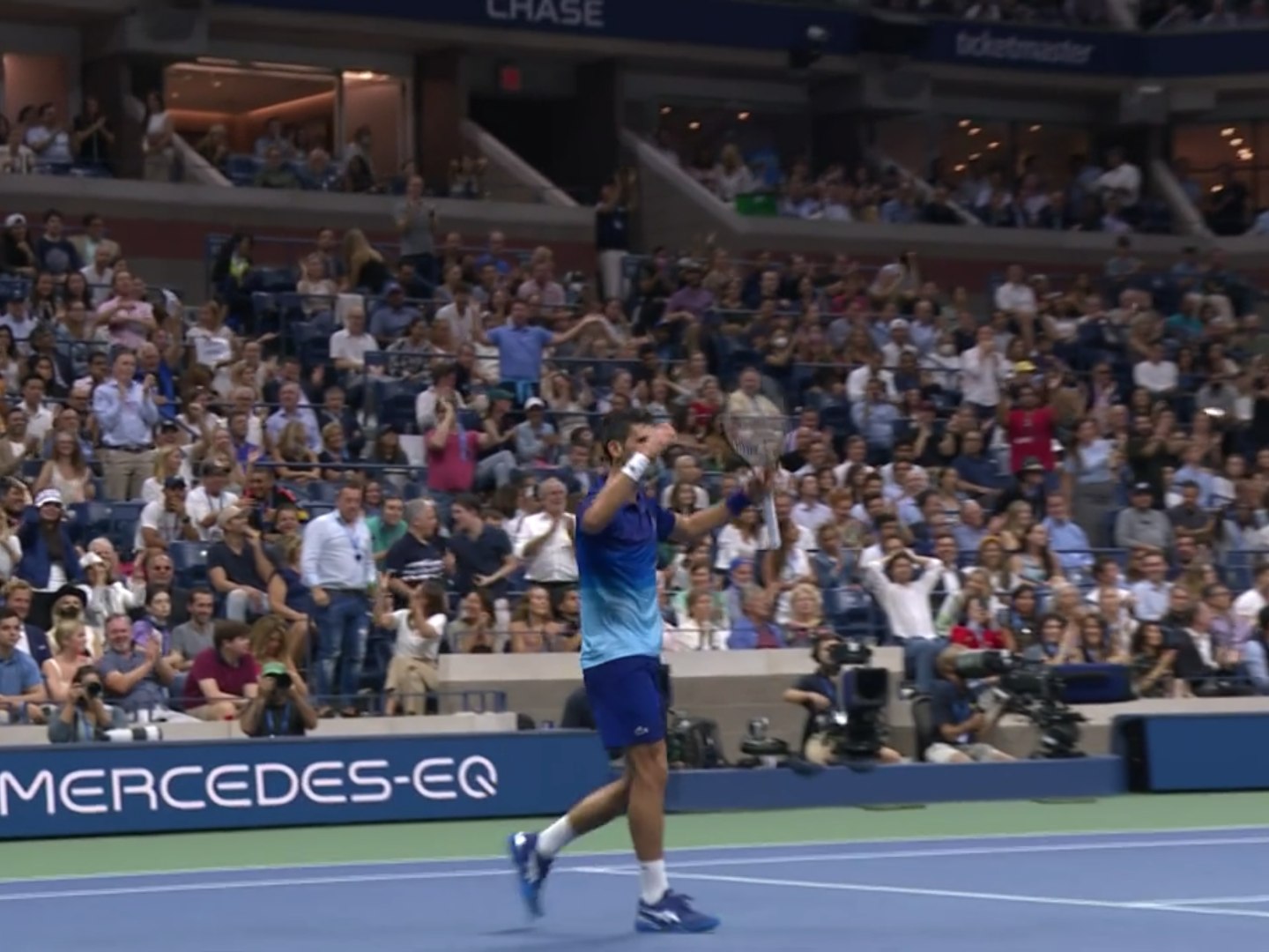 Novak Djokovic raises his arms to the crowd during the US Open