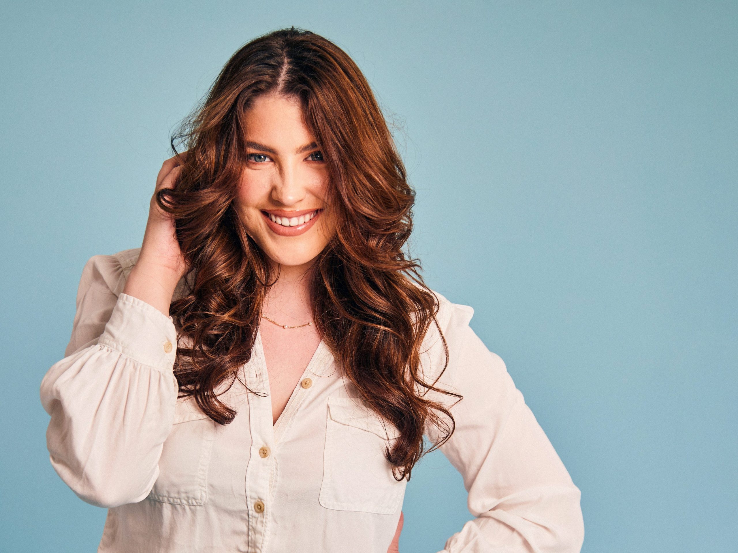 Gigi Robinson in a white shirt in front of a blue background