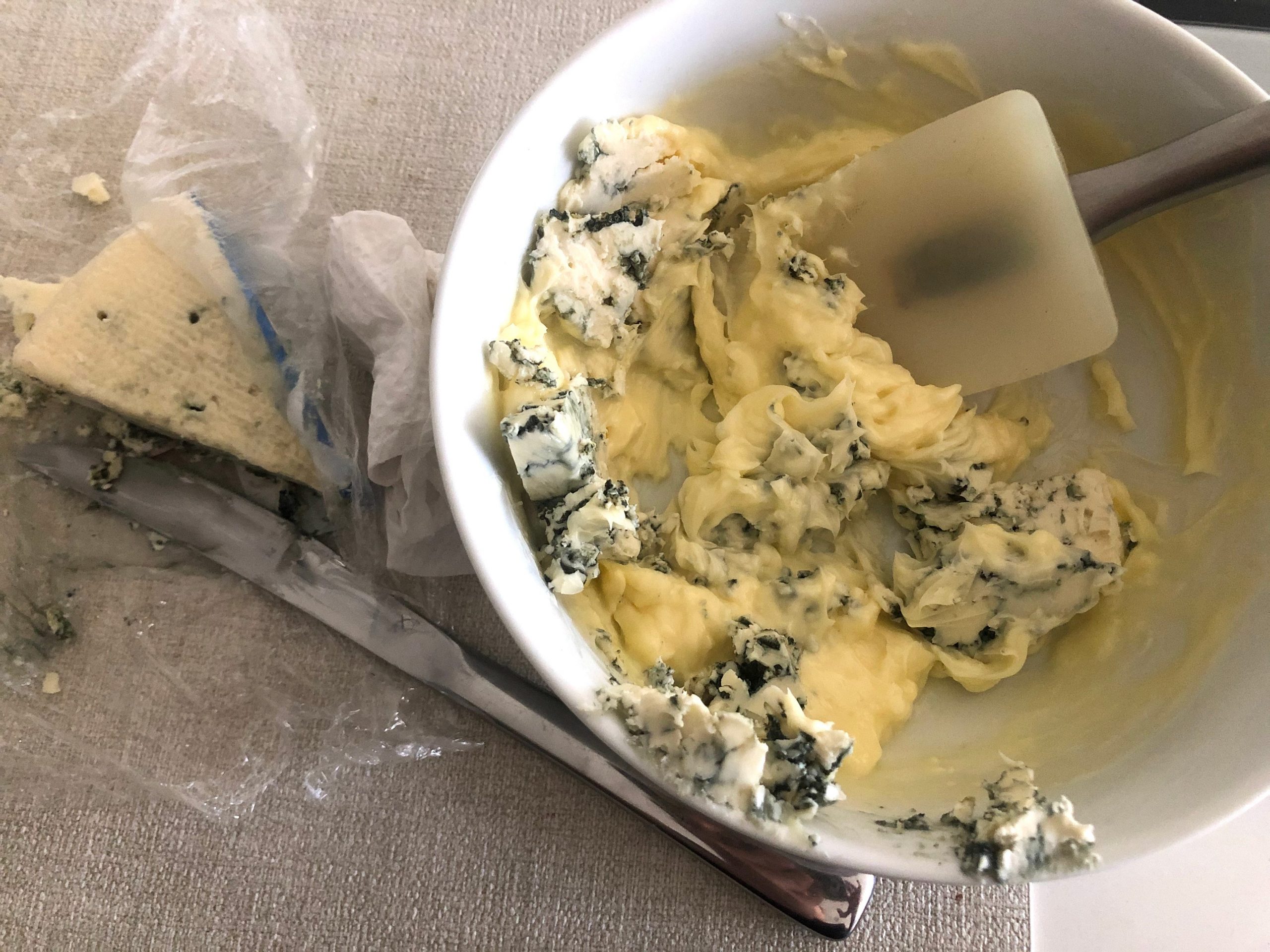 Mixed butter, blue cheese, salt, and pepper in a bowl.