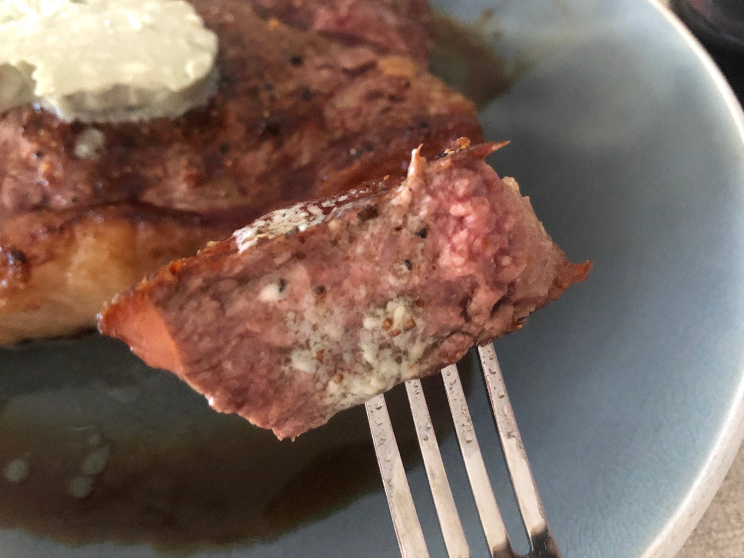 A piece of steak on a fork.