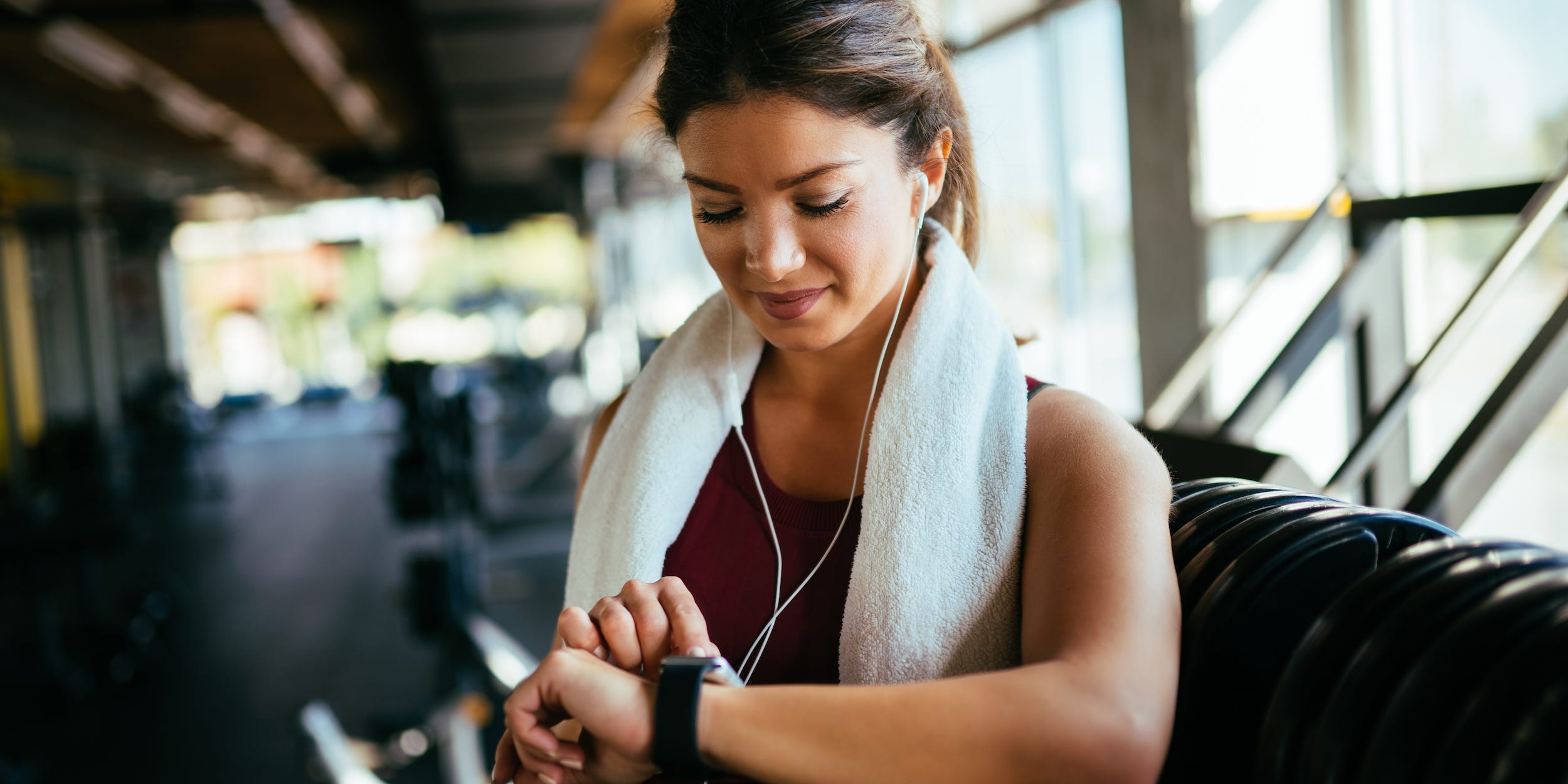 woman exercising in gym looking at smart watch