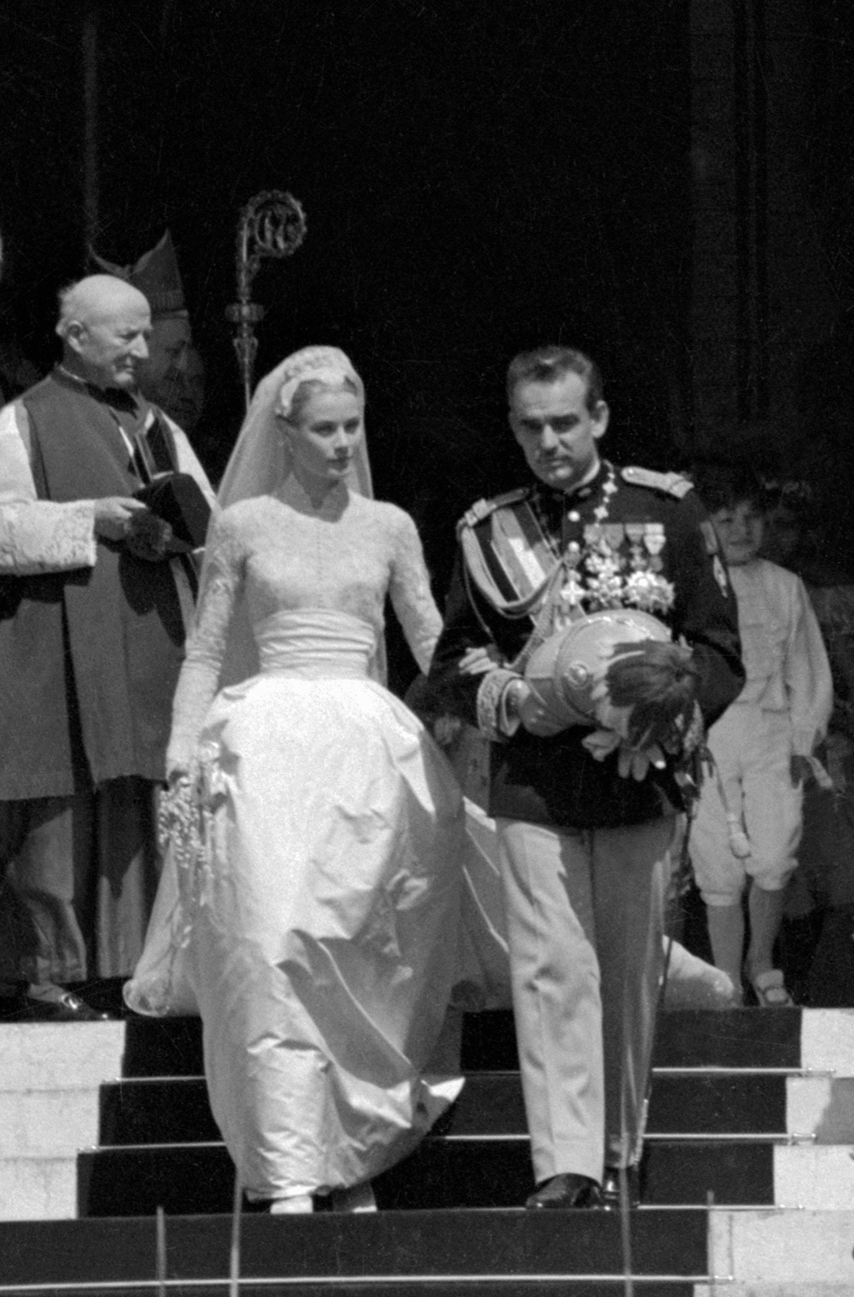 Grace Kelly and the Prince of Monaco walk down a set of stairs on their wedding day.