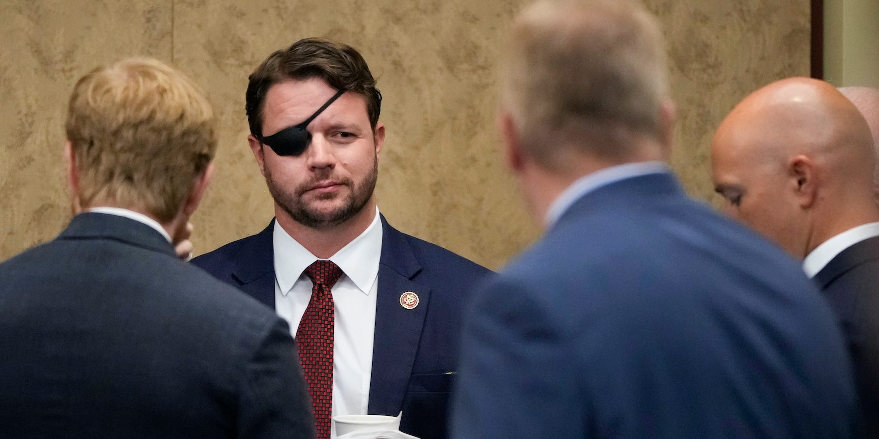 : (L-R) Rep. Darrell Issa (R-CA) and Rep. Dan Crenshaw (R-TX) speak with fellow House Republican members as they gather before a meeting about the American military withdrawal in Afghanistan, at the U.S. Capitol on August 30, 2021 in Washington, DC.