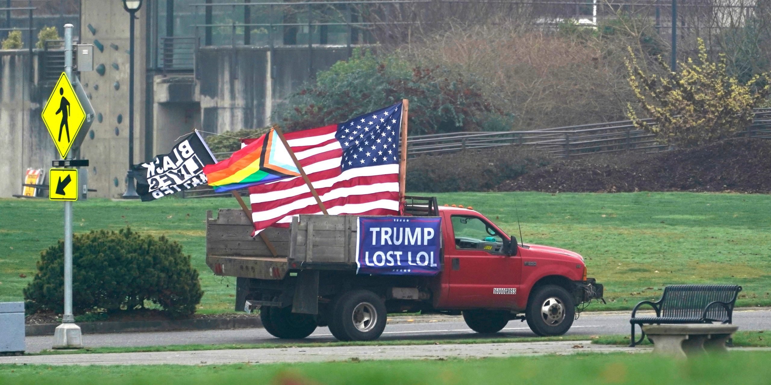 A truck with a flag that says "Trump Lost LOL."