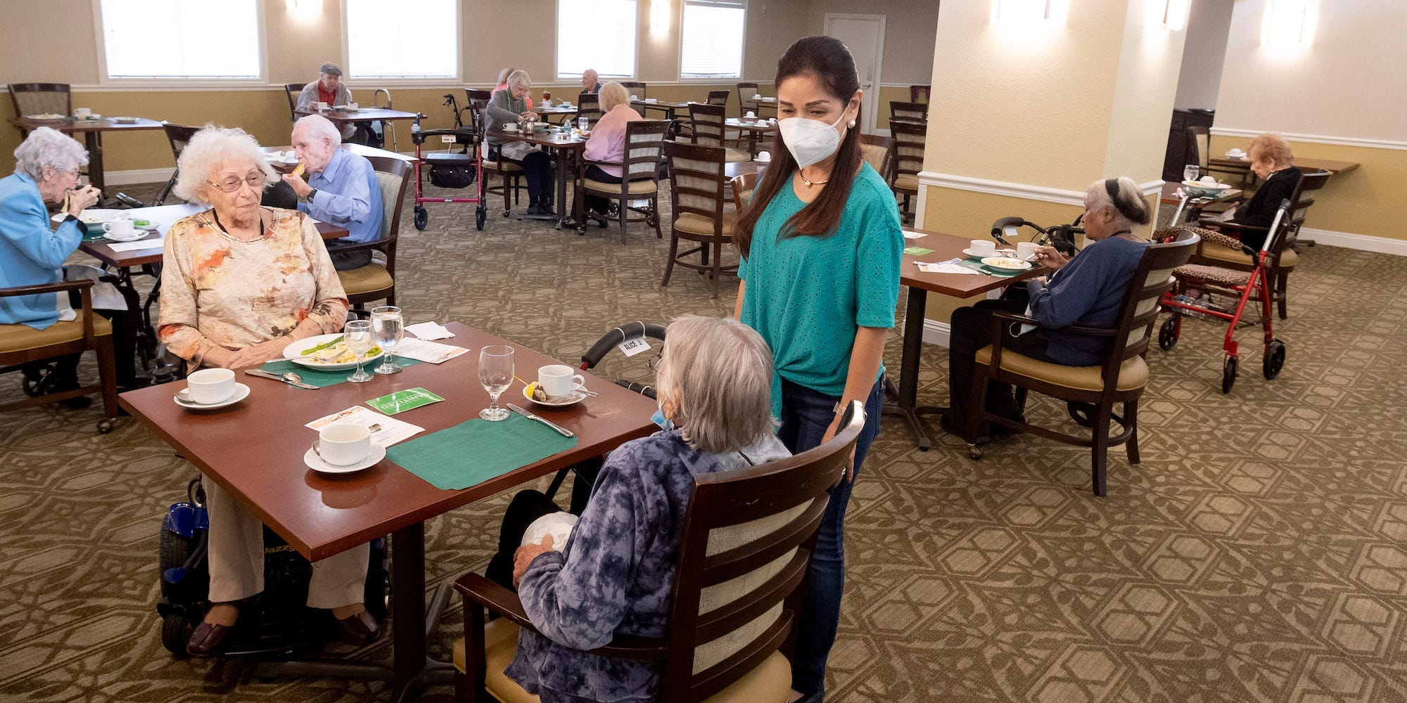 Residents talk with a caregiver in the dining room at Emerald Court in Anaheim, CA on Monday, March 8, 2021.