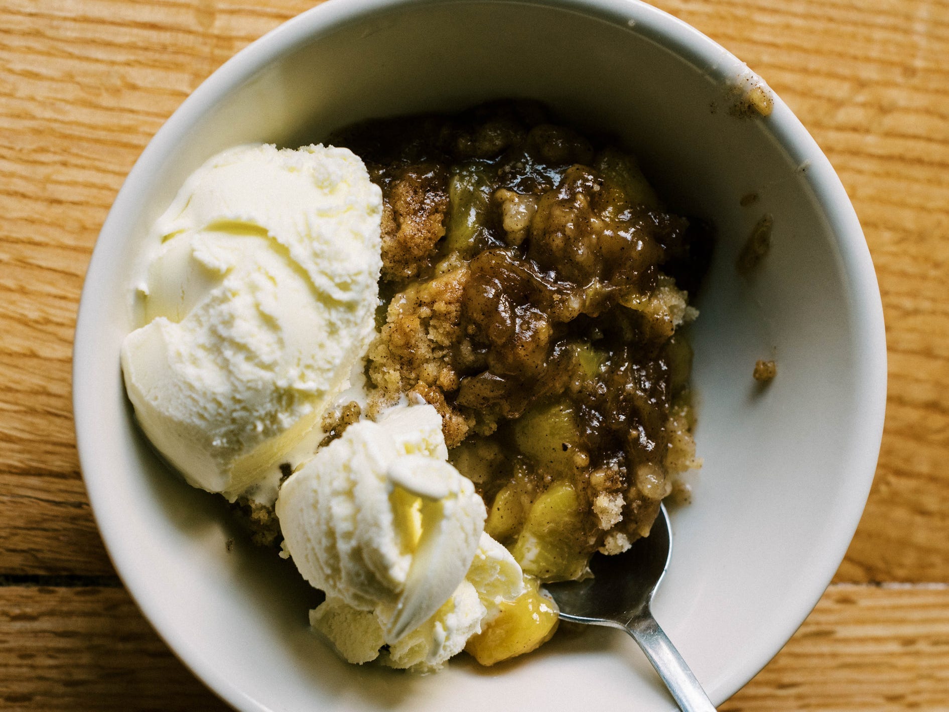 Peach cobbler with ice cream on top.