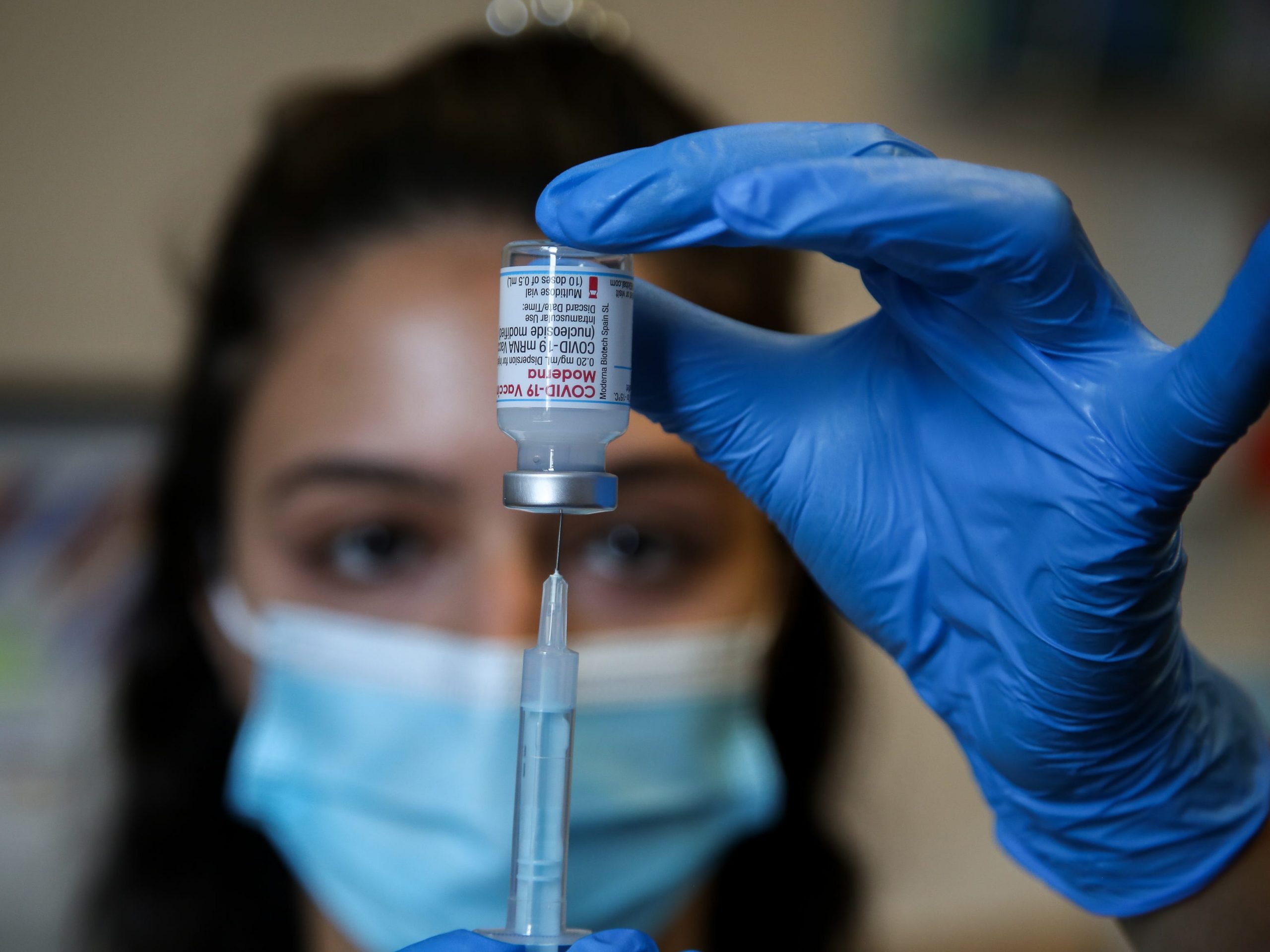 A NHS vaccinator prepares to administer the Moderna Covid-19 vaccine to a member of public at a vaccination centre in London.